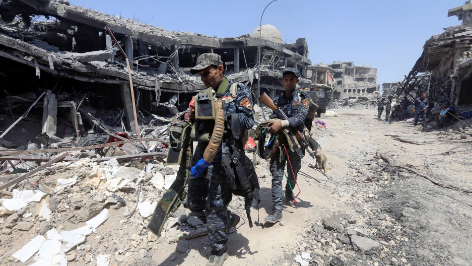 Members of Iraqi Federal police carry suicide belts used by Islamic State militants in the Old City of Mosul. 
