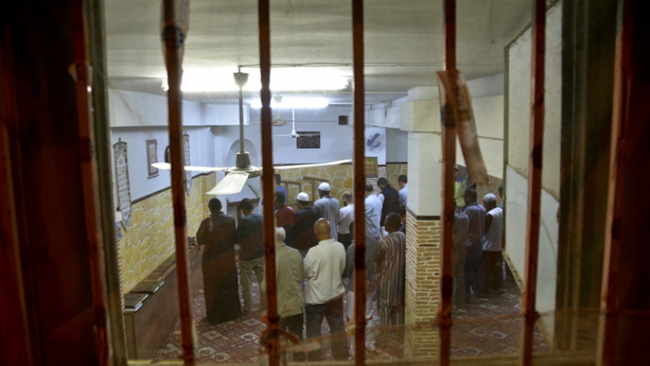 Muslim men gathered in a basement transformed into a a prayer room in the neighborhood of Agios Nikolaos, in Athens