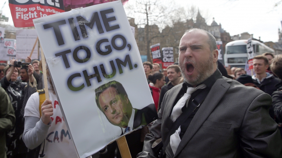 Demonstrators hold placards during a protest in London on April 9, 2016. British Prime Minister David Cameron said on Saturday he should have handled scrutiny of his family's tax arrangements better and promised to learn the lessons after days of negative