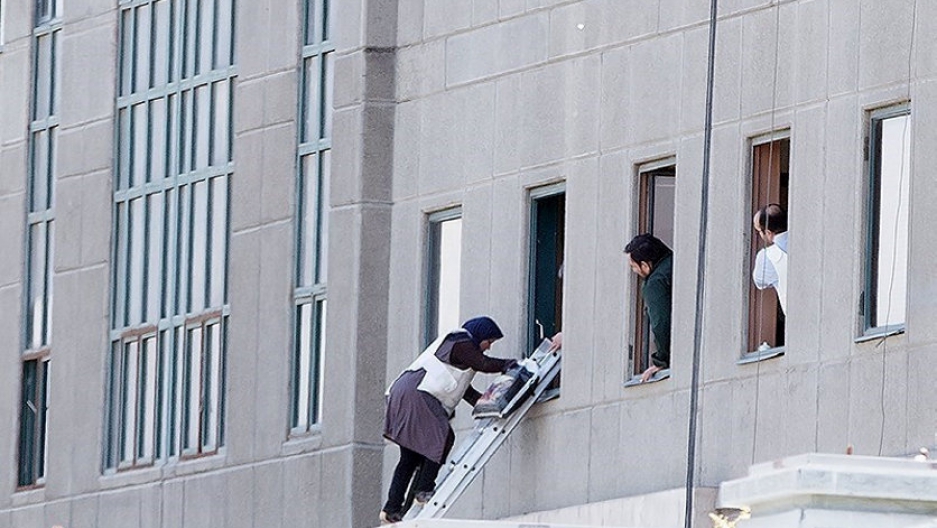 A woman is evacuated during an attack on the Iranian parliament in central Tehran, Iran.