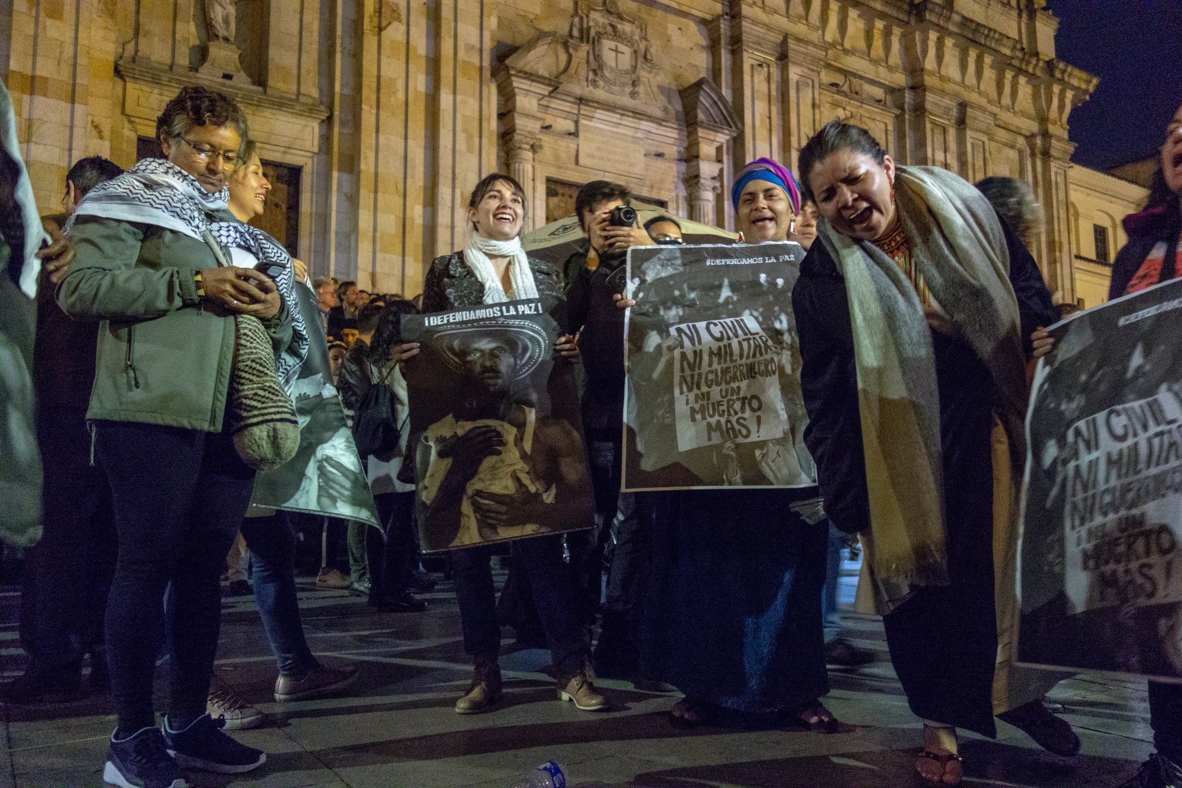 Protesters shout and stand on streets with signs.