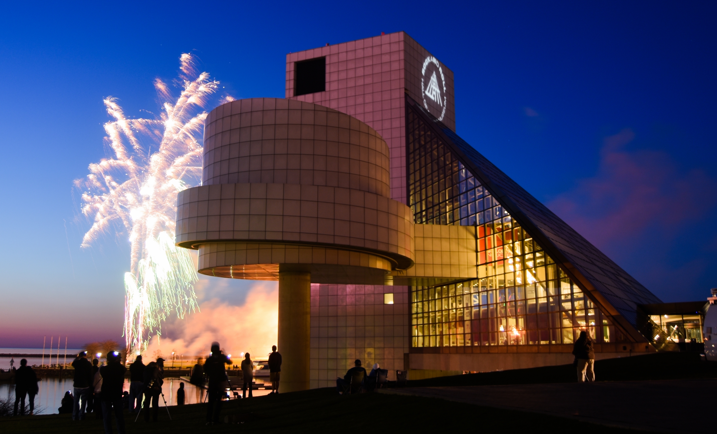 The 150,000 square-foot building has a one of Pei's glass pyramids: a glass-enclosed double pyramid next to a 162-foot tower. Fireworks flash next to the Rock and Roll Hall of Fame at night.