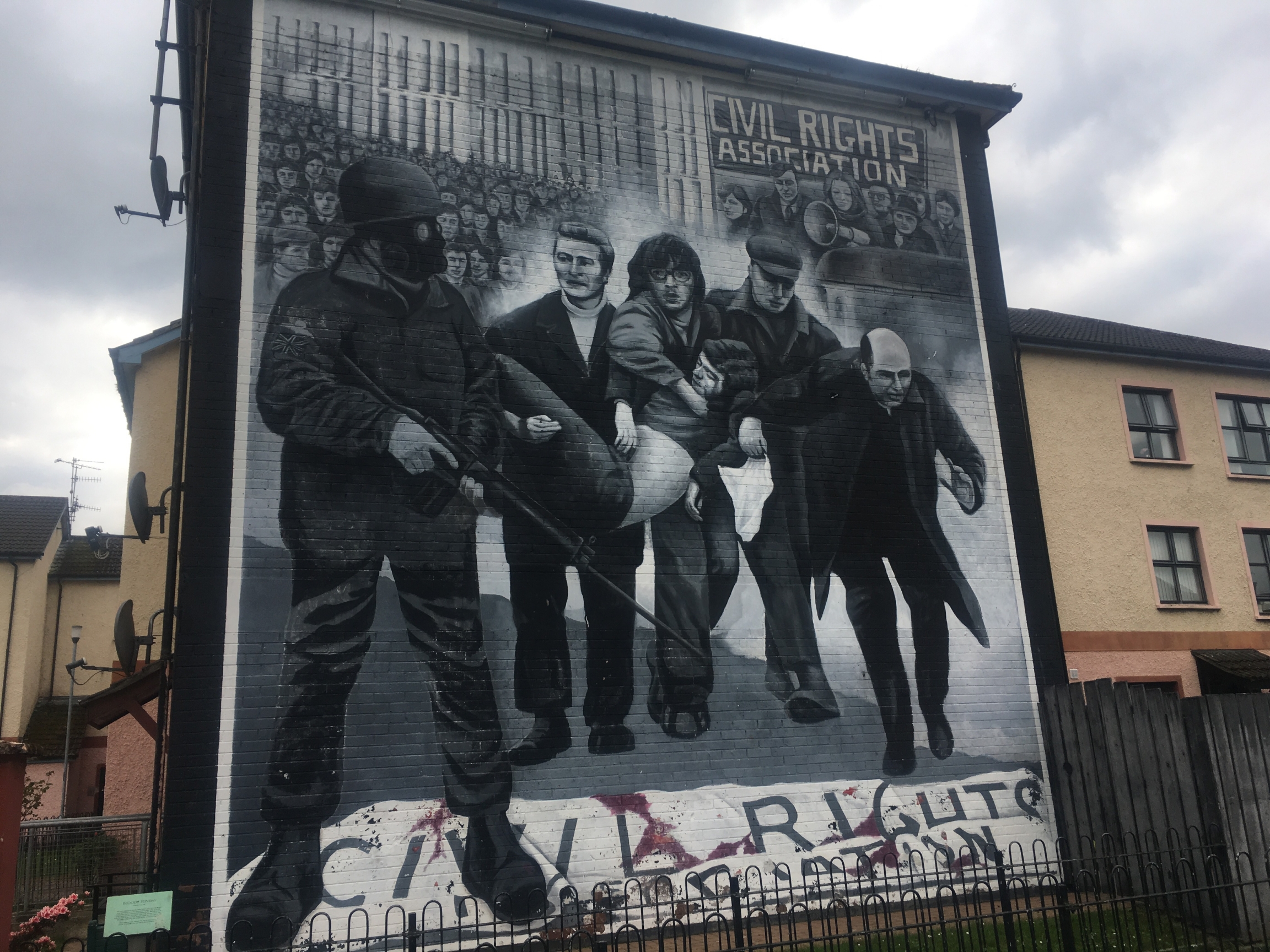 A large black and white mural takes up the entire wall of a multi-story building