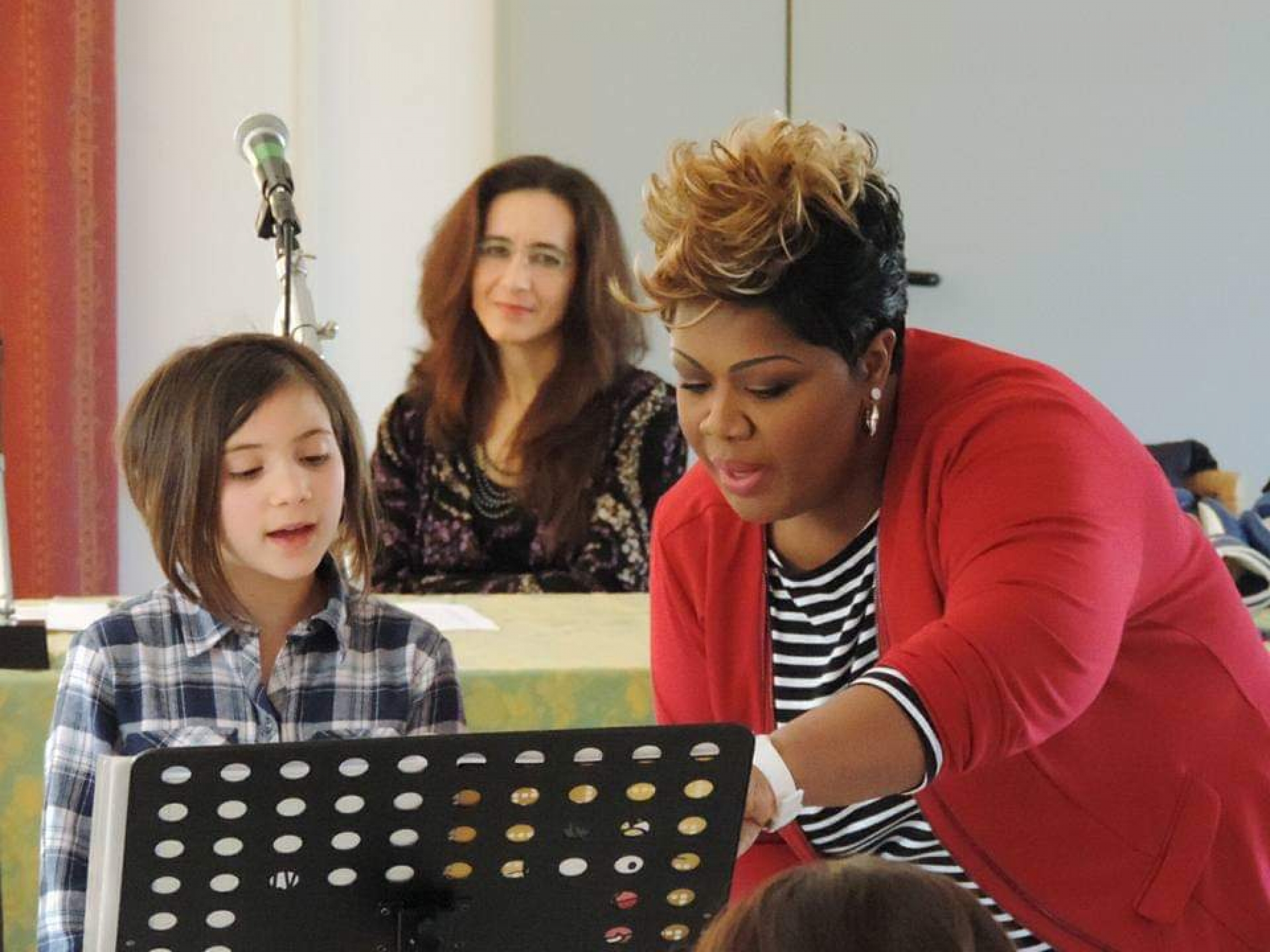 Cheryl Porter voice master class. Woman shows a child musical notes on a paper