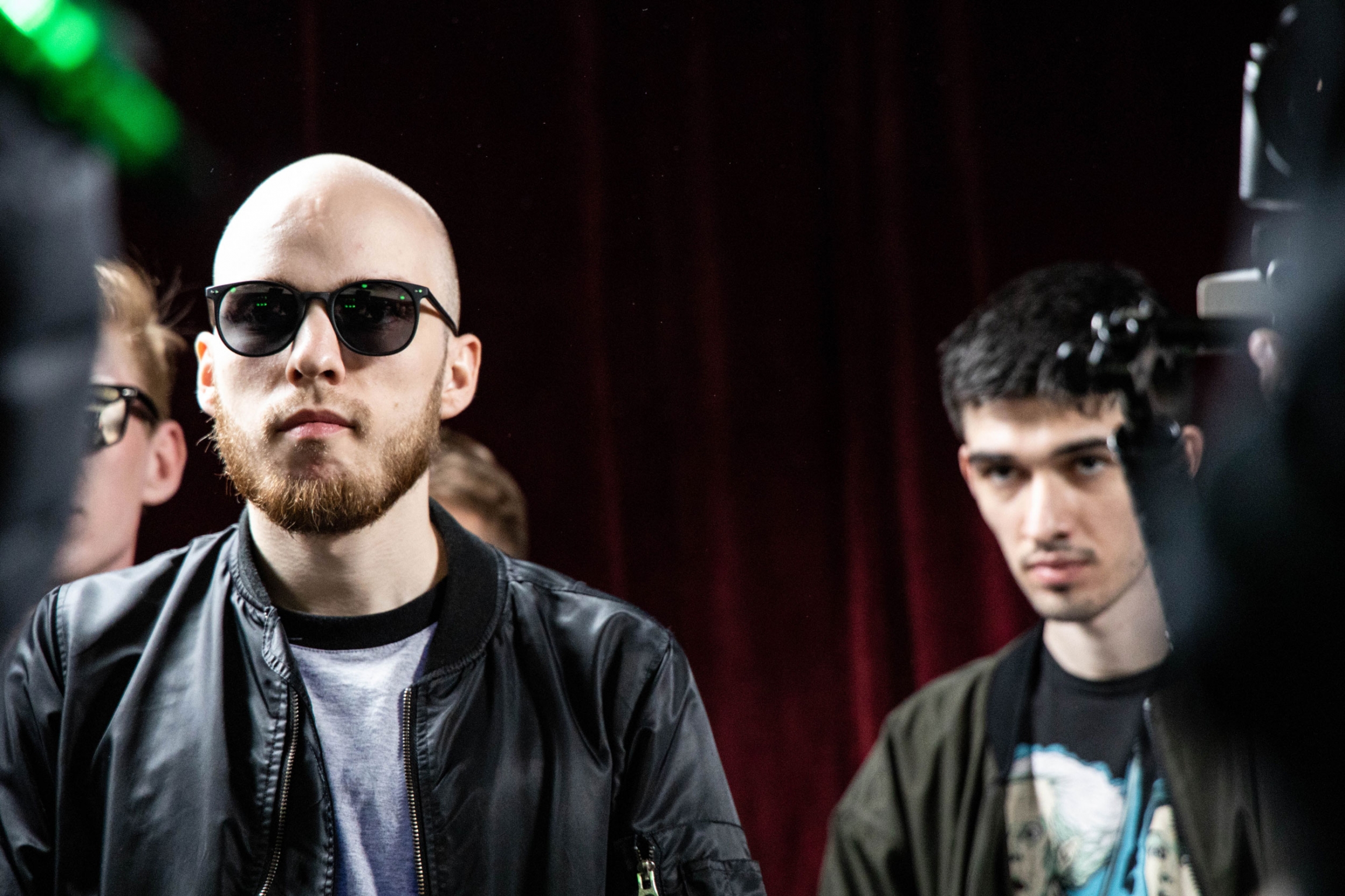 Dmitri Kapranov (left), watches a performance in the Alibi Club in Moscow. Kapranov is the Moscow coordinator of the Slova Project, an organization that hosts rap battles all over the Russian-speaking world, and judge in the rap battle. Two men stand next to each other and watch a rap battle.