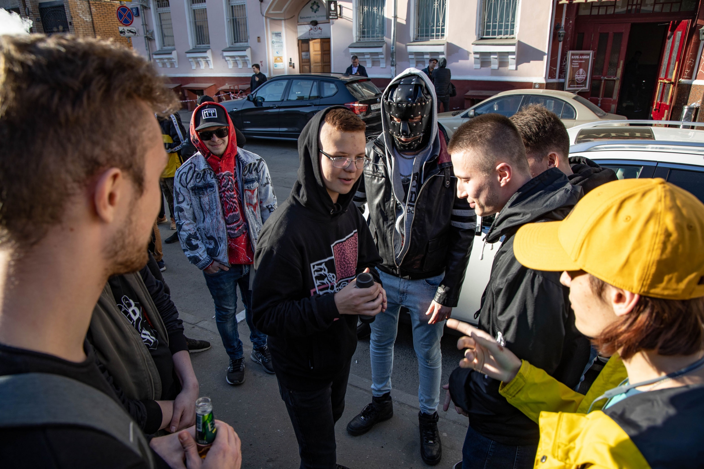 Rap is now the most popular music genre in Russia amongst teenagers and people in their 20s. A group of rappers and spectators hold sidewalk freestyle battles outside the Alibi Club before the event. Young men talk outside while preparing for a rap battle.
