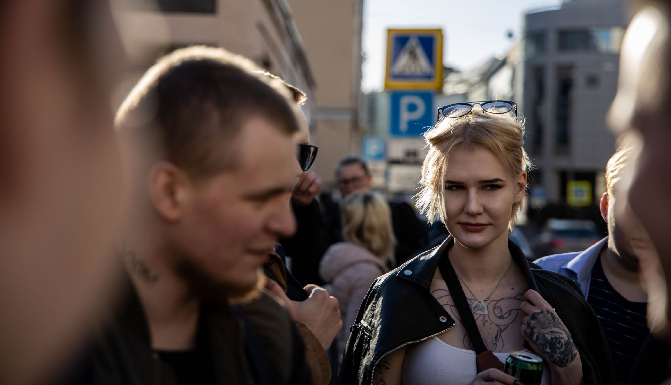 People gather before the rap battle. The crowd filled the Alibi Club. A woman with tattoos stands in a crowd outside a club.