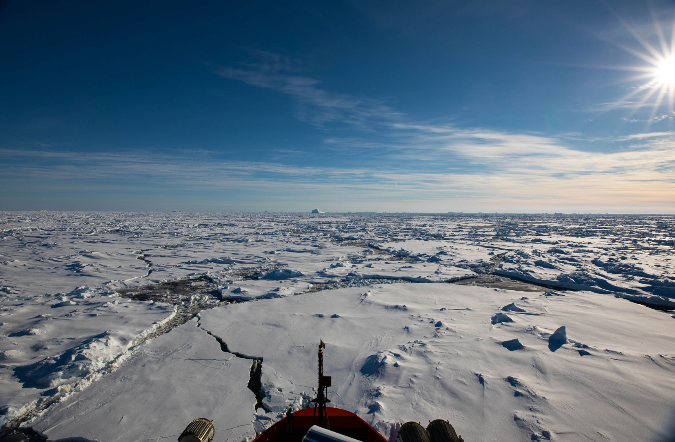 The Nathaniel B. Palmer breaking through ice floes during its southward transit. The front of the Nathaniel B. Palmer ship is shown at the bottom of the photo breaking through ice floes.