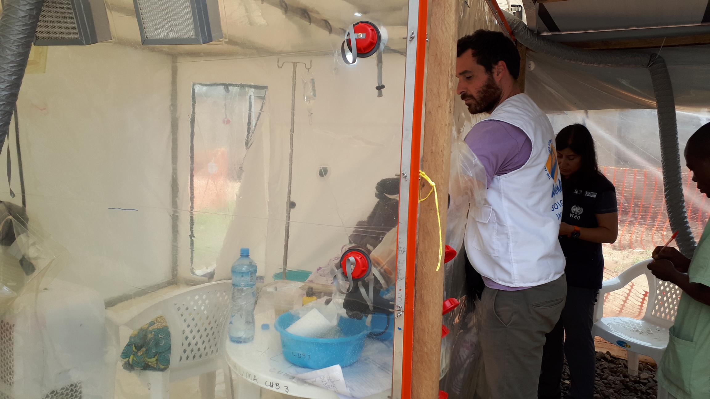 A health worker shows how the gloves work in the CUBE