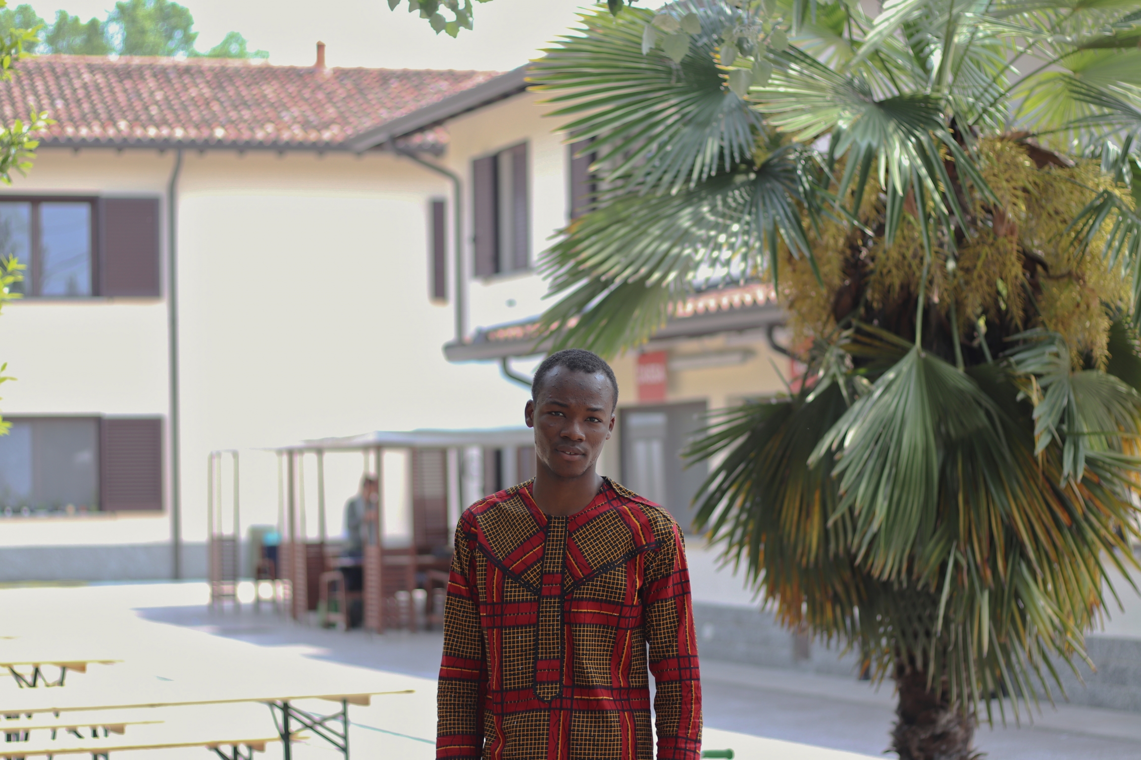 a refugee stands in front of a building in italy