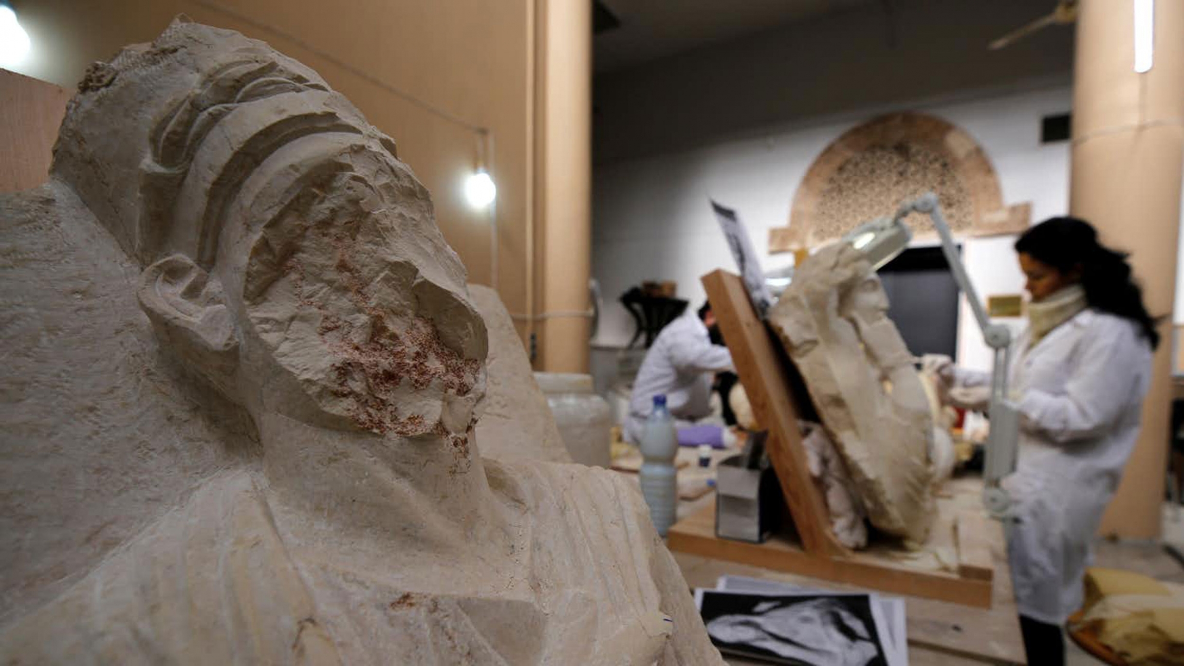 Specialists work on damaged statues from Palmyra at Syria’s National Museum of Damascus in January 2019. A woman works on damaged statues - one is missing part of its face - from Palmyra at Syria’s National Museum of Damascus