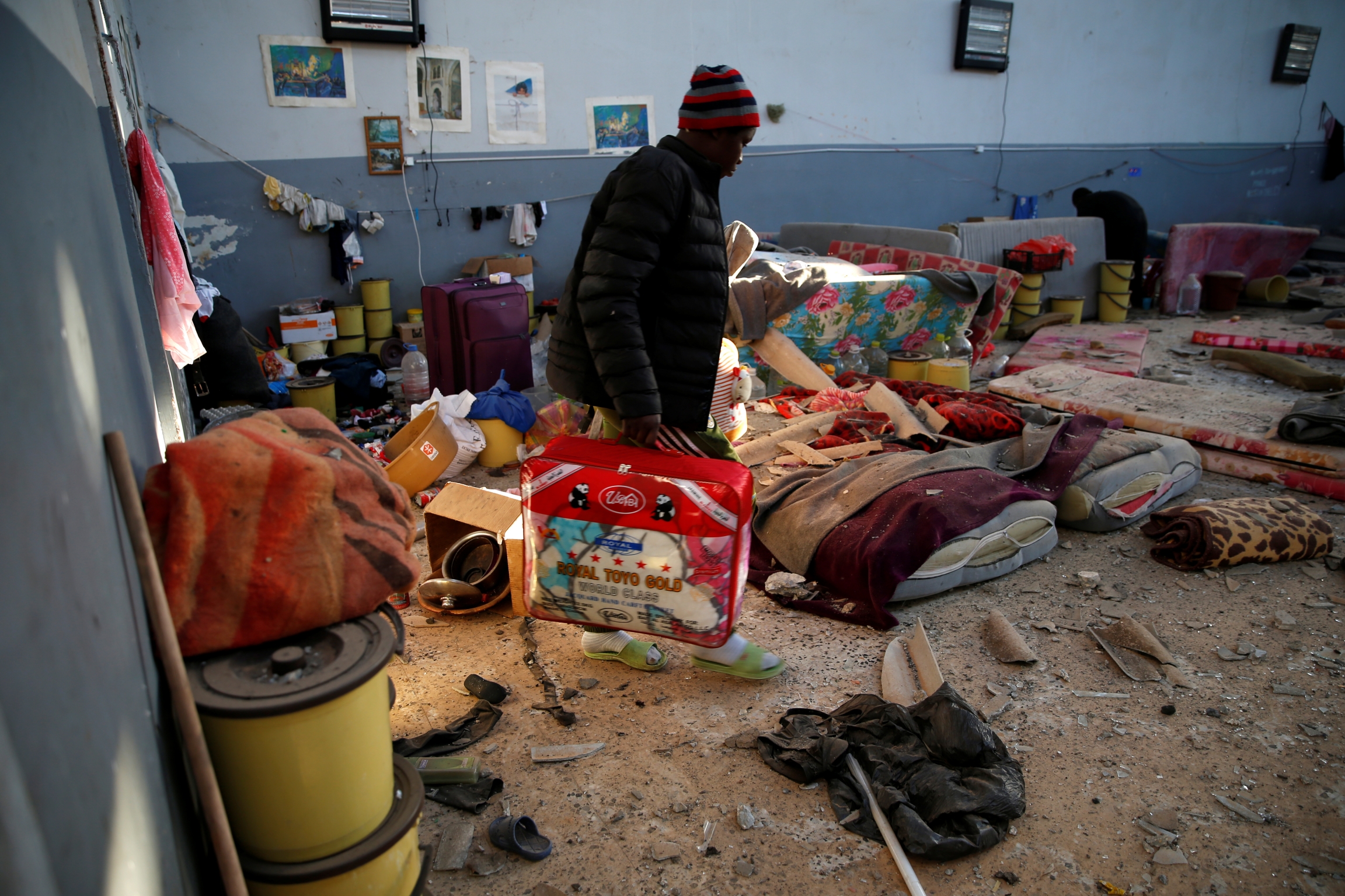 migrant carries belongings out of detention center