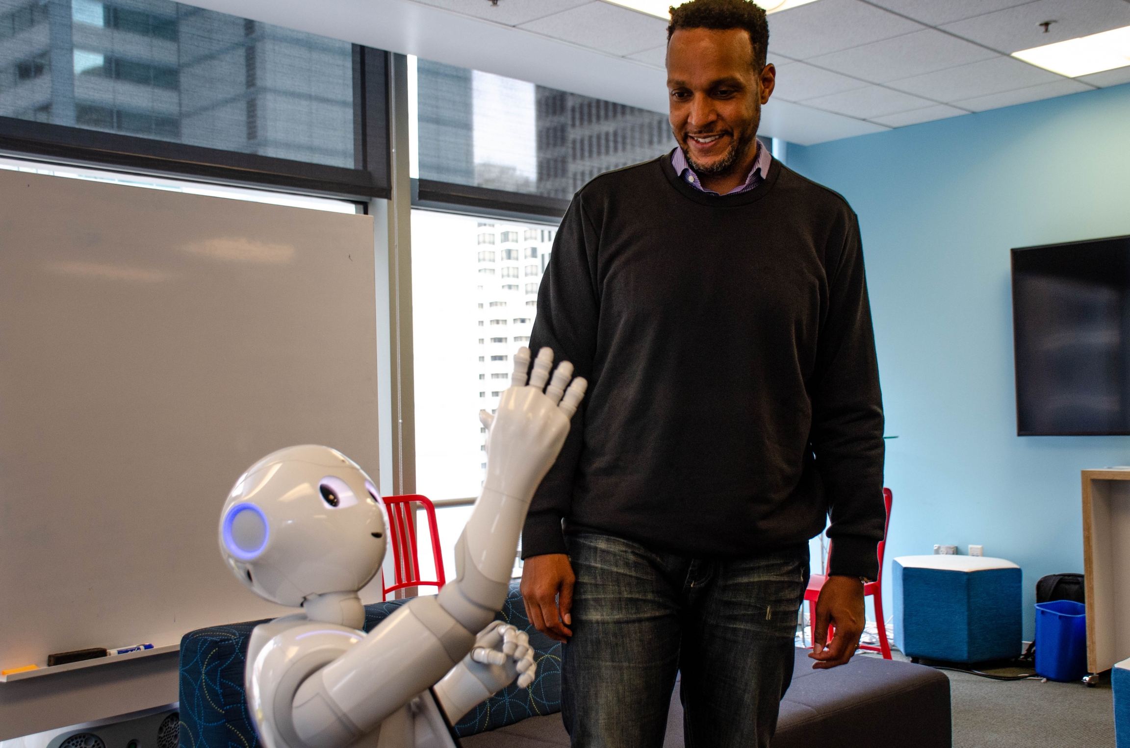 Softbank Robotics’ Kass Dawson, who stands 6’5” interacts with Pepper, the robot. Dawson says Pepper was designed to be four-feet-tall to make it more “approachable.” Softbank Robotics’ Kass Dawson, who stands 6’5” interacts with Pepper, the robot. Dawson says Pepper was designed to be four-feet-tall to make it more “approachable.”
