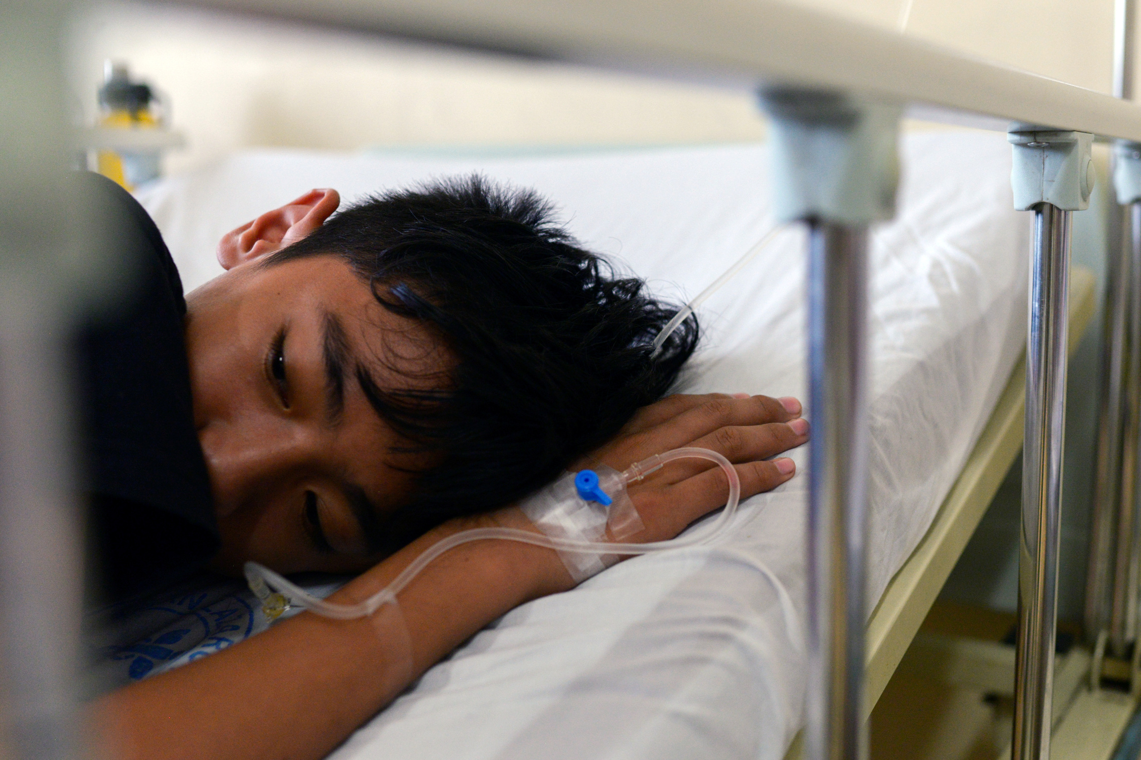 A boy recuperates from dengue fever in a hospital in Manila. A boy lays down in a hospital bed.