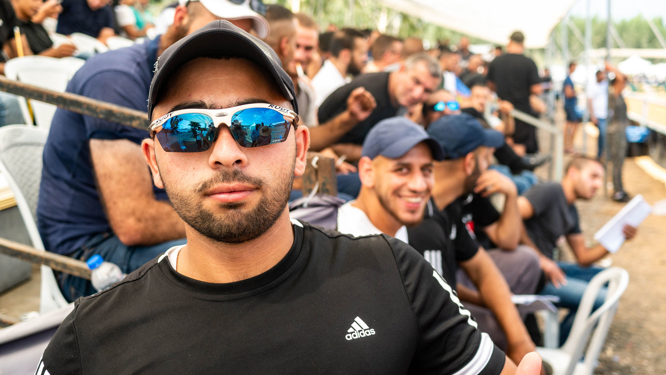 Muhammad Ghazi is a 21-year-old restaurant worker from Nazareth. He says he won't bother voting in Tuesday's national election. A man is shown wearing a dark shirt, mirrored sunglasses and a white hat.