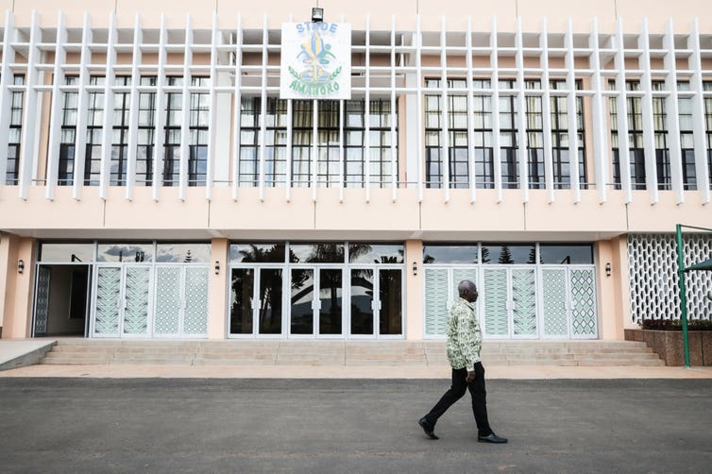 Former UN peacekeeper Peter Sosi, seen here in spring 2019, at the Kigali stadium to which he evacuated Tutsi refugees during the 1994 Rwandan genocide. A man walks in front of a building.