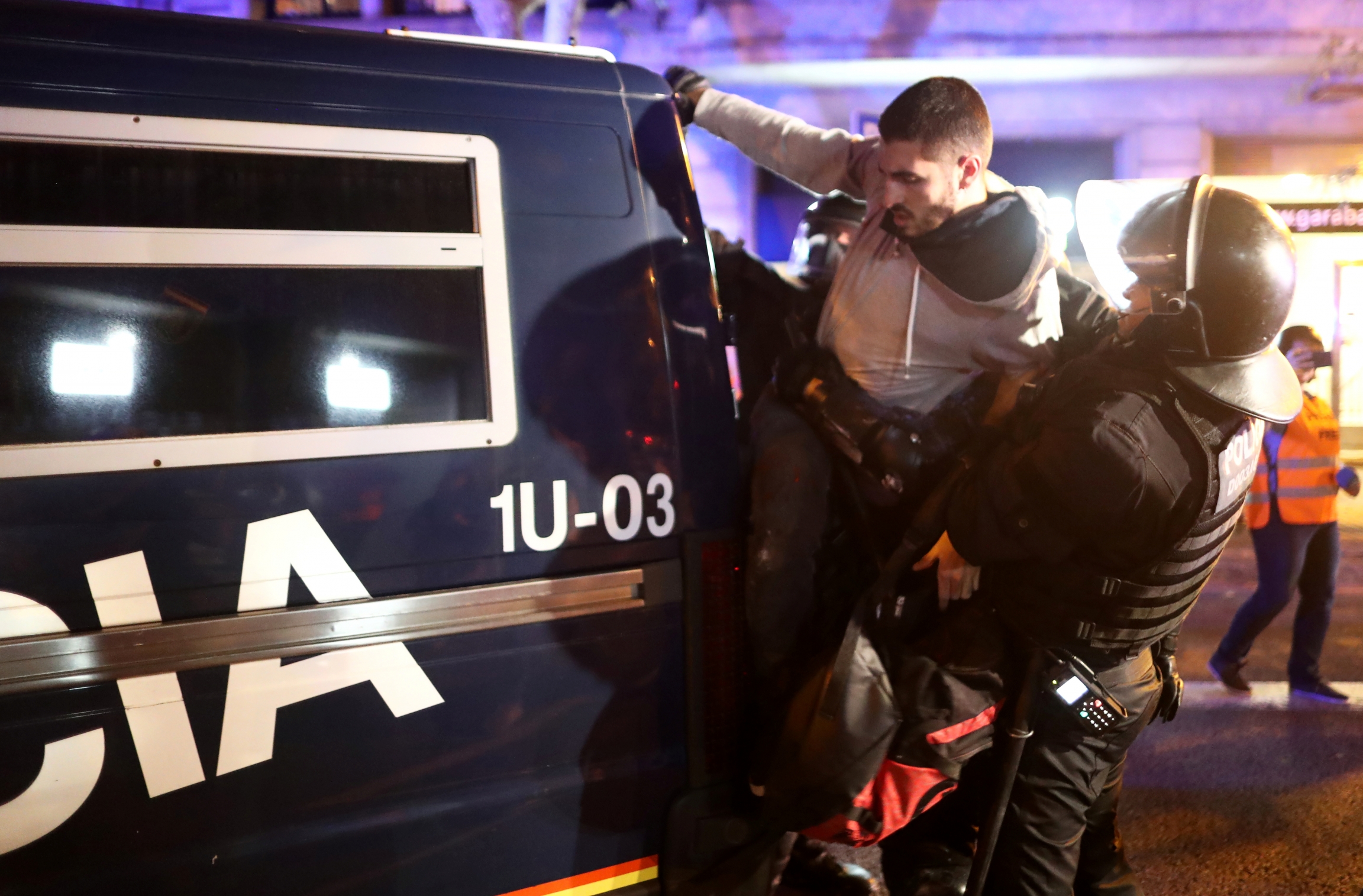 protester detained by police in riot gear