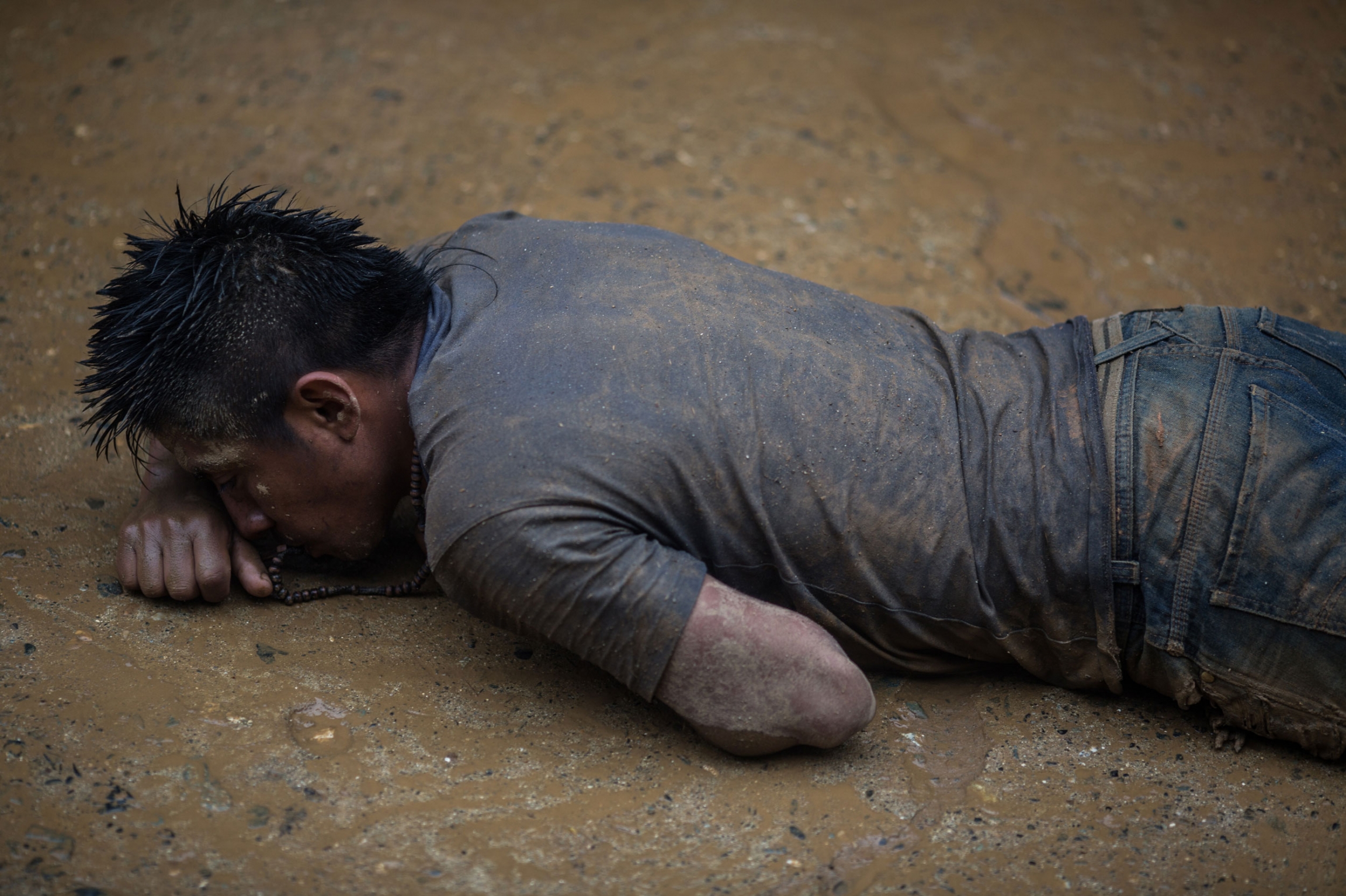 Pilgrims do not hesitate to crawl on their hands, elbows and knees in the mud and rock of the mountain as an offering in exchange for a miracle. A man is shown crawling on his stomach in the mud and covered in dirt.