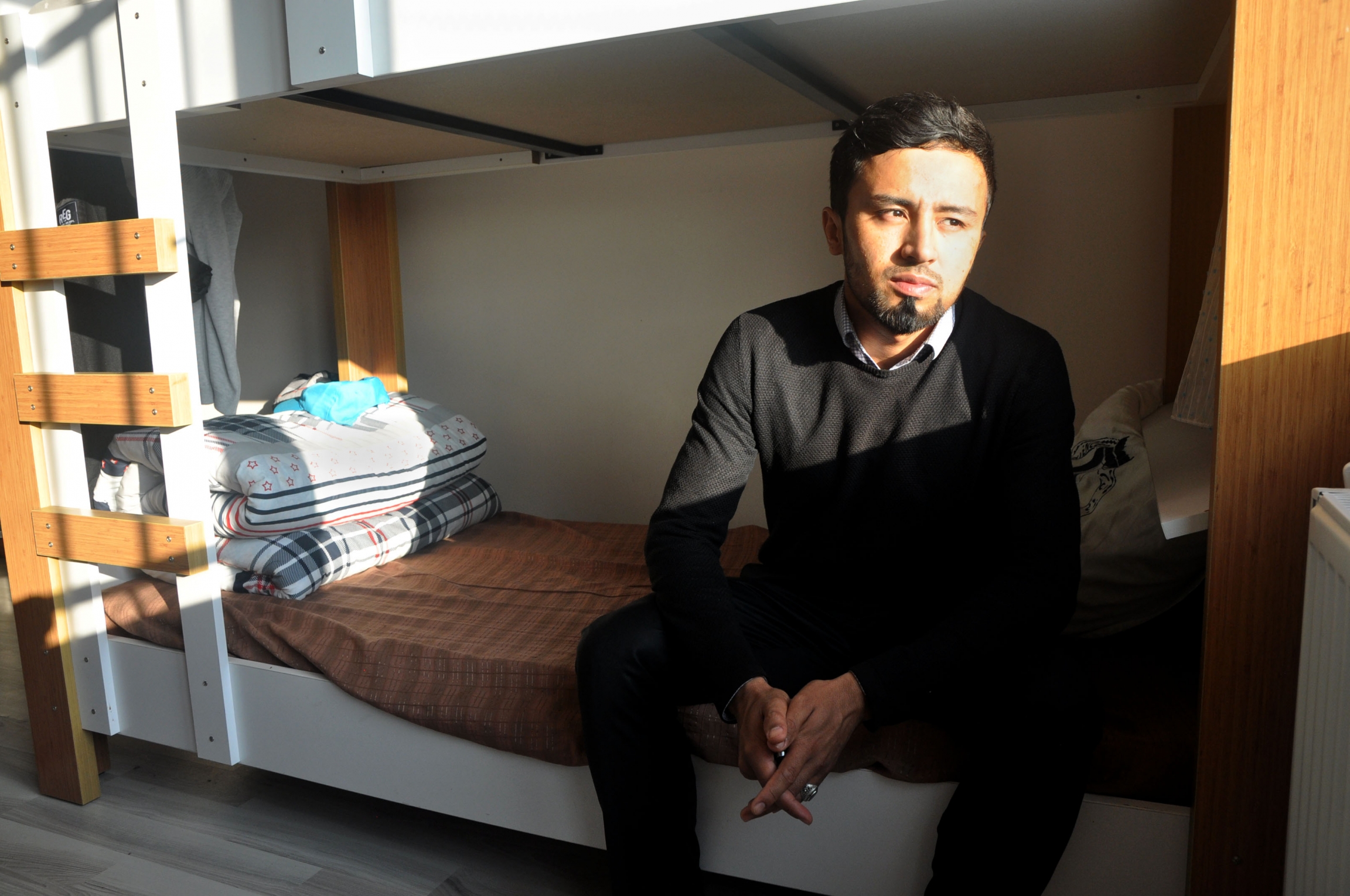 Mohammed Izatullah, 30, sits on a bunk bed in the dormitory. Mohammed Izatullah, 30, sits on a bunk bed in the dormitory.