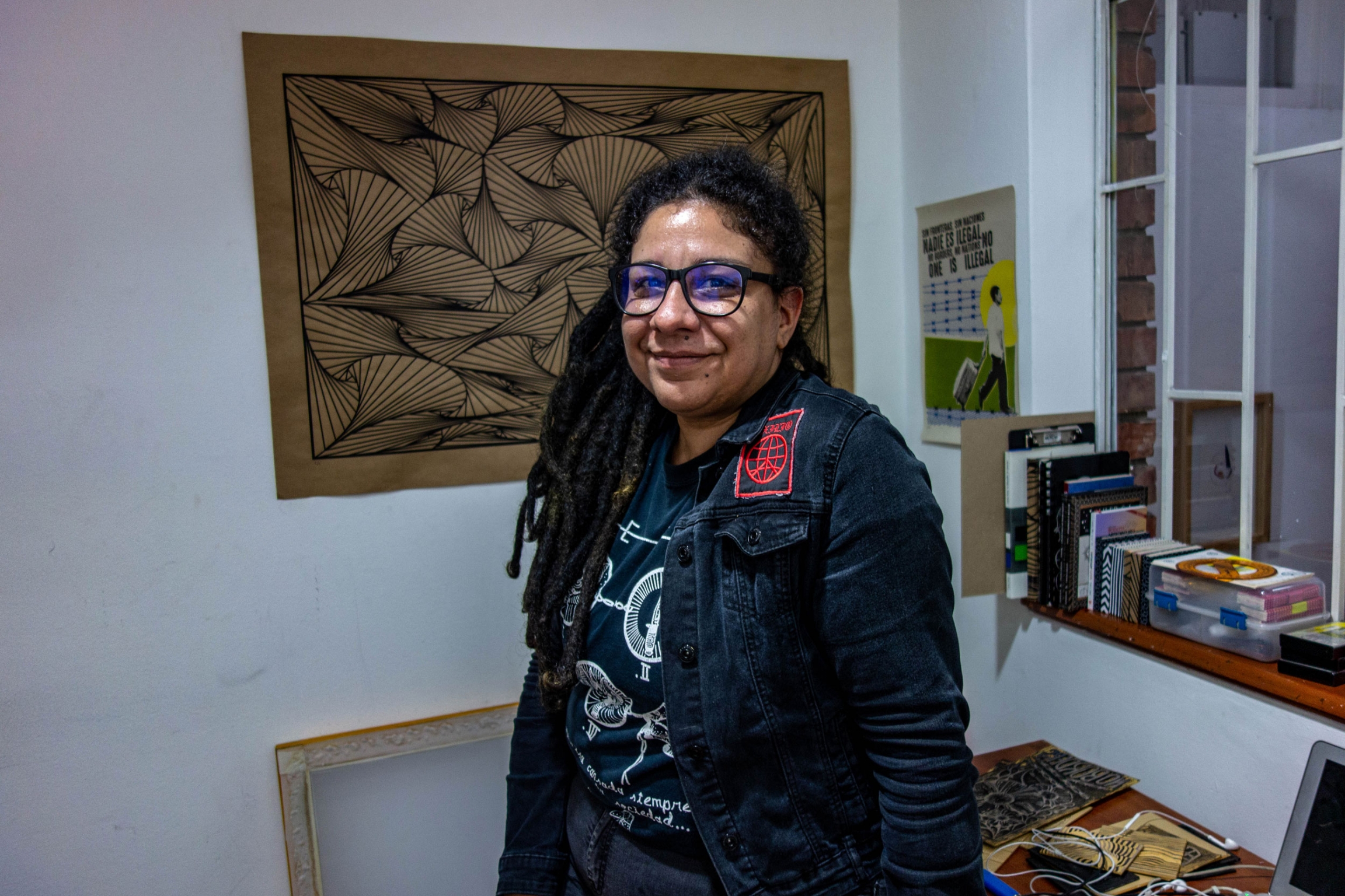 Susana González, lead singer of Exilio in her office at the cooperative arts space in which she works. Exilio singer Susana González is shown wearing dread locks and glasses.