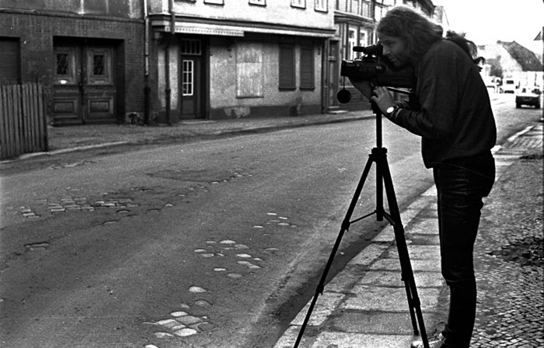 Siegbart Schefke in the former German Democratic Republic. Siegbart Schefke is shown standing behind a camera on a tripod.