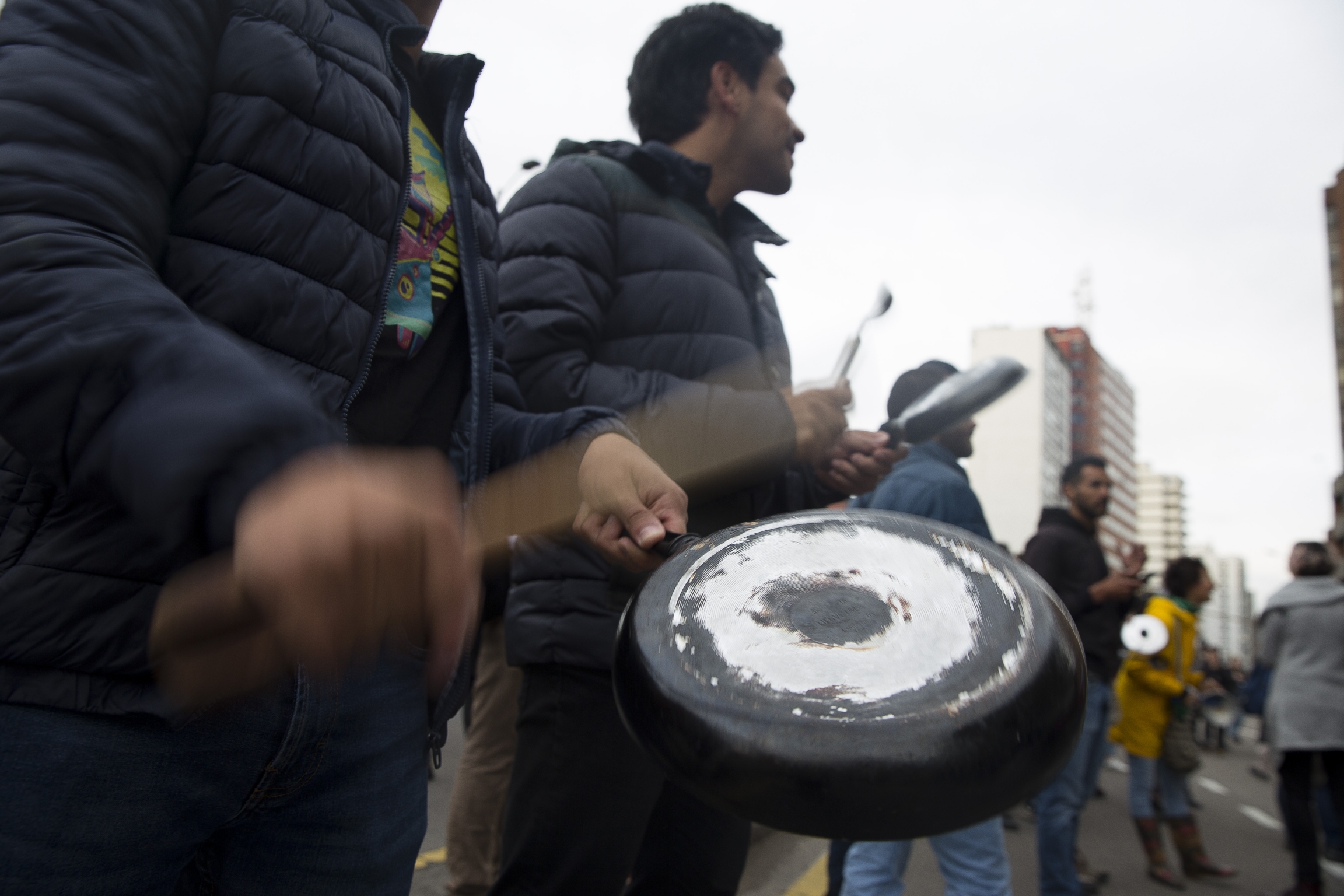 Colombian demonstrators bangs pots and yell in a Latin American protest tradition called cacerolazo, in Bogotá, Colombia, on Nov. 22, 2019. A man bangs on a pot