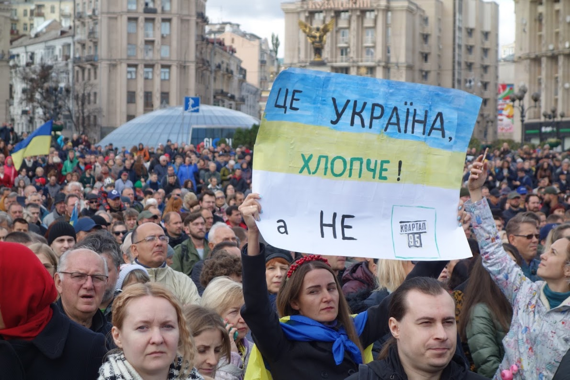 A protester holds a sign to call out Ukrainian President Volodymyr Zelenskiy during a protest on Oct. 2, 2019, in Kyiv, Ukraine. "It's Ukraine, dude, not Kvartal 95," the sign reads, a reference to Zelenskiy's former production company. A protester holds a hand-written sign to call out Ukrainian President Volodymyr Zelenskiy during a protest.