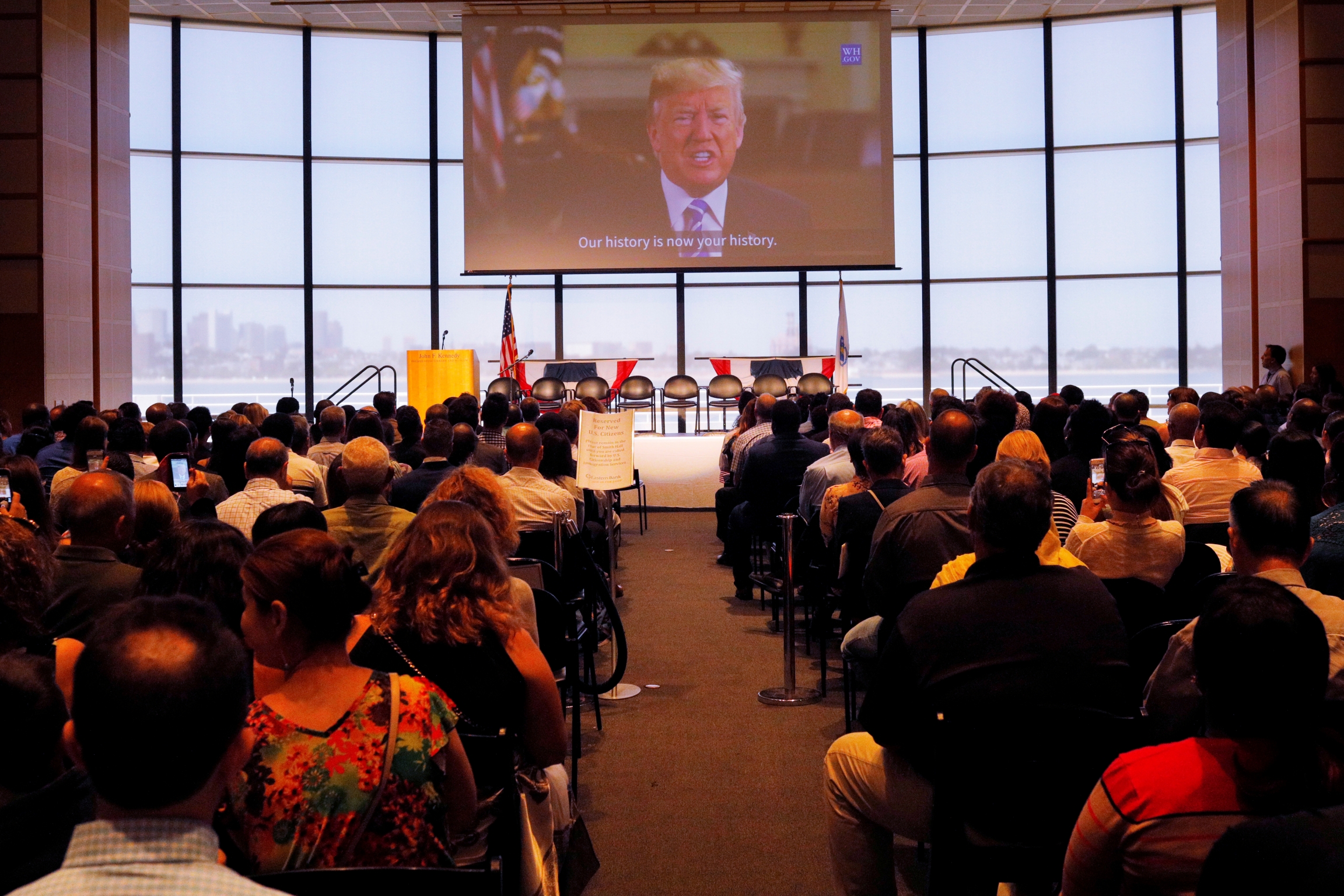 A welcome statement from US President Donald Trump is played after a citizenship ceremony at the John F. Kennedy Presidential Library in Boston, Massachusetts, on July 18, 2018. A welcome statement from US President Donald Trump is played after a citizenship ceremony at the John F. Kennedy Presidential Library in Boston, Massachusetts, on July 18, 2018.