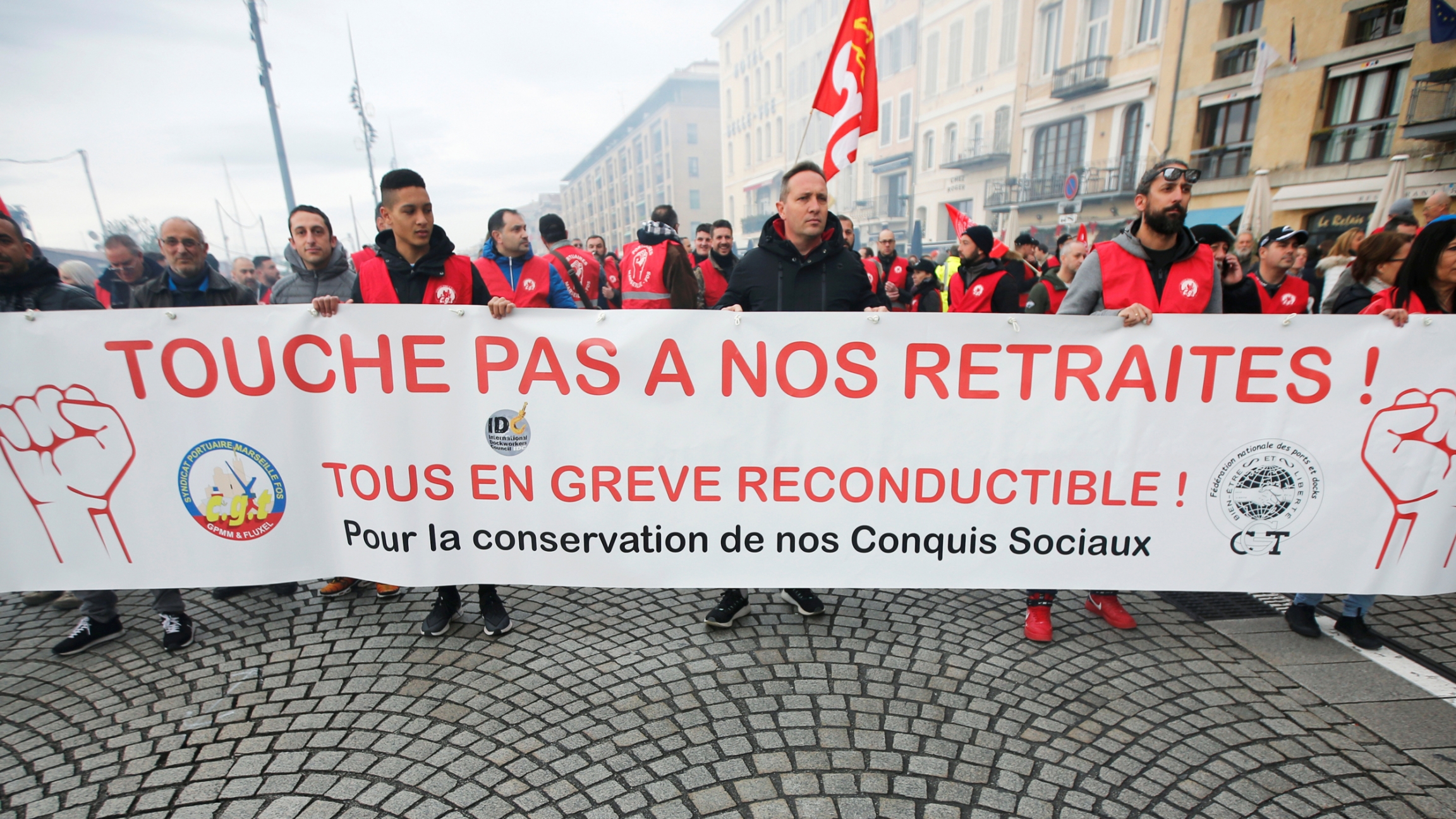 Protesters hold a banner during a demonstration against French government's pensions reform plans in Marseille as part of a day of national strike and protests in France, Dec. 5, 2019. The banner reads, "Don't touch my pension." A large group of protesters are shown in the street holding a banner during a demonstration in Marseille. The banner reads, "Don't touch my pension."