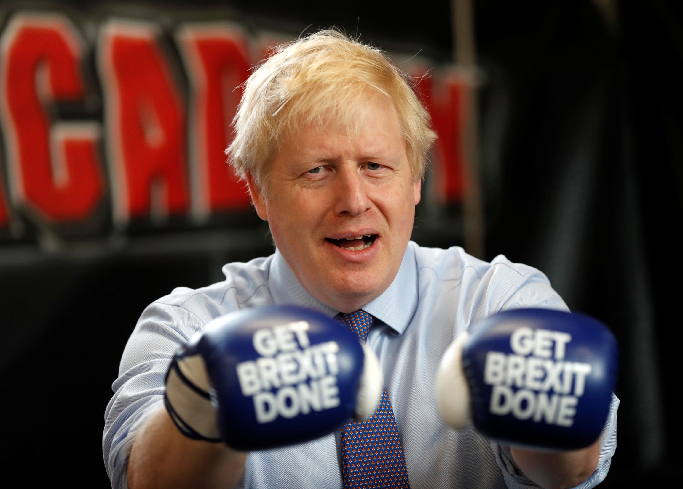 Britain's Prime Minister Boris Johnson poses for a photo wearing boxing gloves during a stop on the campaign trail in Manchester, Britain, Nov. 19, 2019. Britain's Prime Minister Boris Johnson is shown wearing blue boxing gloves with the words "Get Brexit Done" printed on them.
