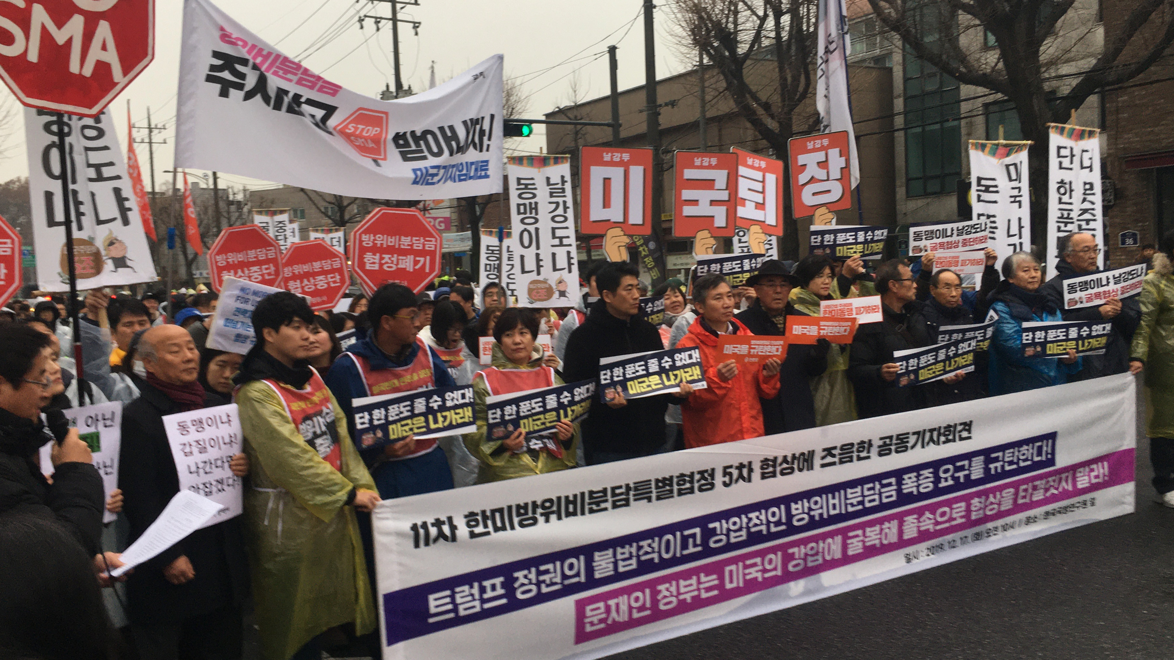 A small, but vocal minority say South Korea shouldn’t pay anything to host the US forces and many of those want the American military to leave their country altogether, and marched on Dec. 17, in Seoul, South Korea. A group of protesters march with a large banner with large words in Korean language