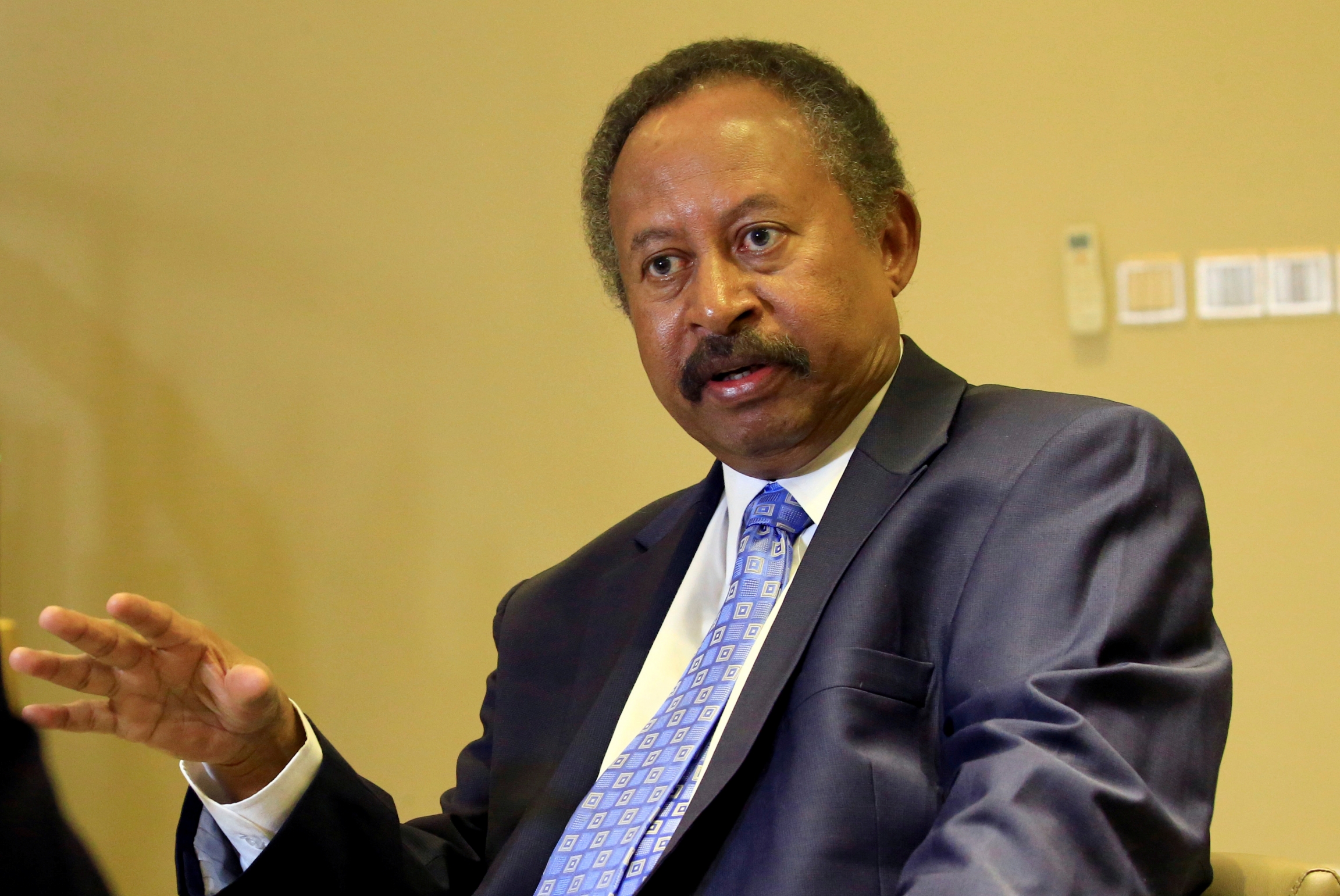 Sudan's prime minister in the transitional government, Abdalla Hamdok, speaks during a Reuters interview in Khartoum, Sudan, Aug. 24, 2019 Abdallah Hamdok in a gray suit with blue tie