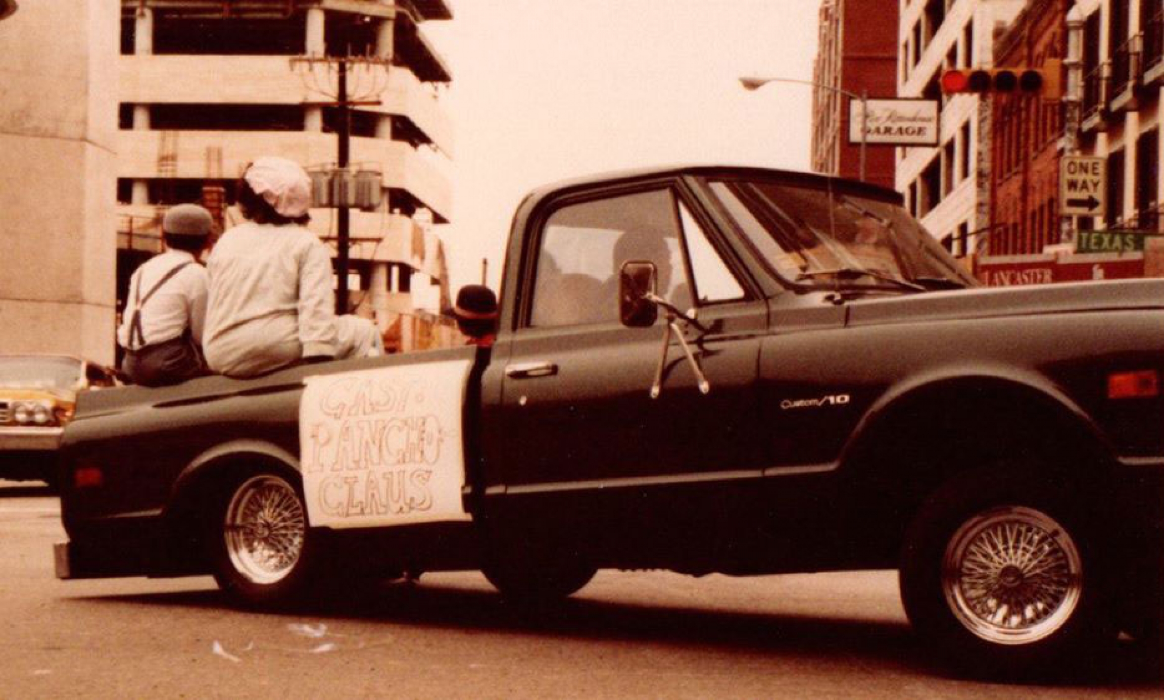 The Pancho Claus cast in Houston's Christmas parade. A pickup truck is shown with three people sitting in the back.