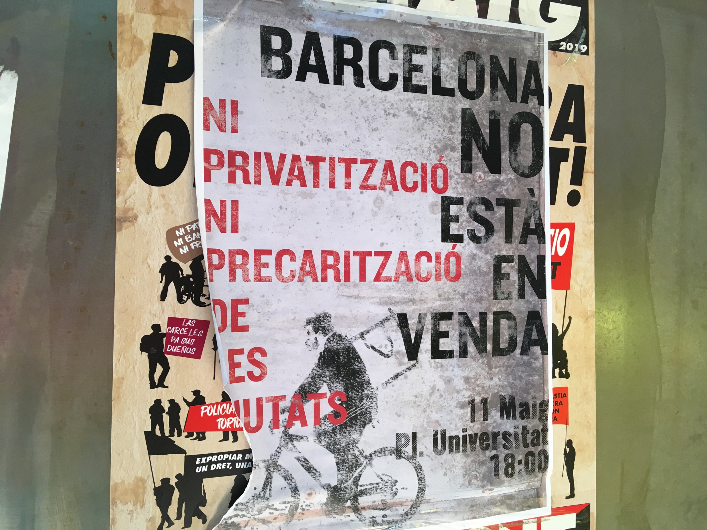 A poster reading “Barcelona is not for sale” advertises a rally to protest against privatization in Barcelona’s University Square in the Eixample district on June 18, 2019 A red, black and white poster on a wall
