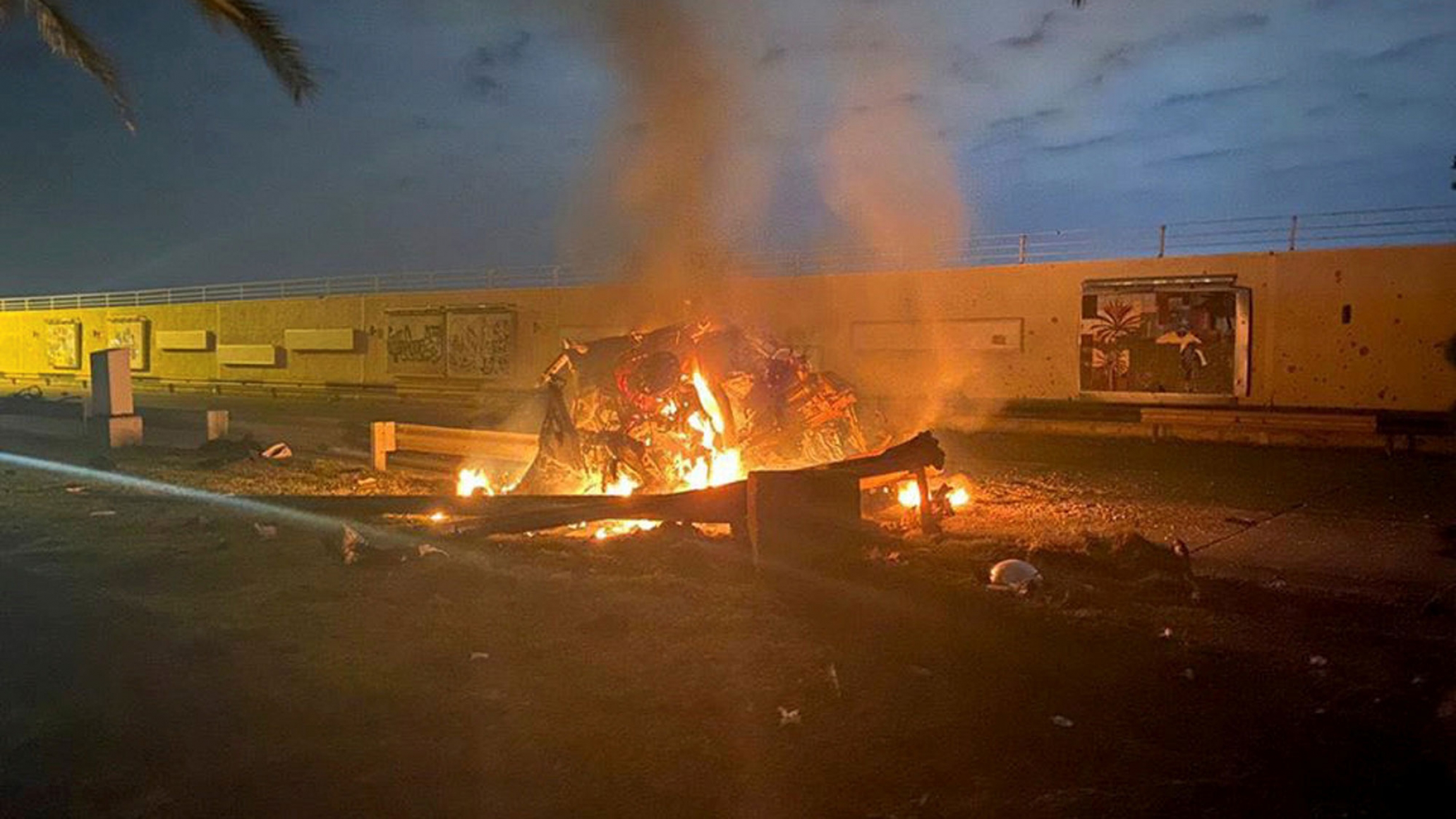 Burning debris are seen on a road near Baghdad International Airport, which according to Iraqi paramilitary groups were caused by three rockets hitting the airport in Iraq, Jan. 3, 2020, in this image obtained via social media. A fire from a rocket attack is shown in a photo taken during low light.