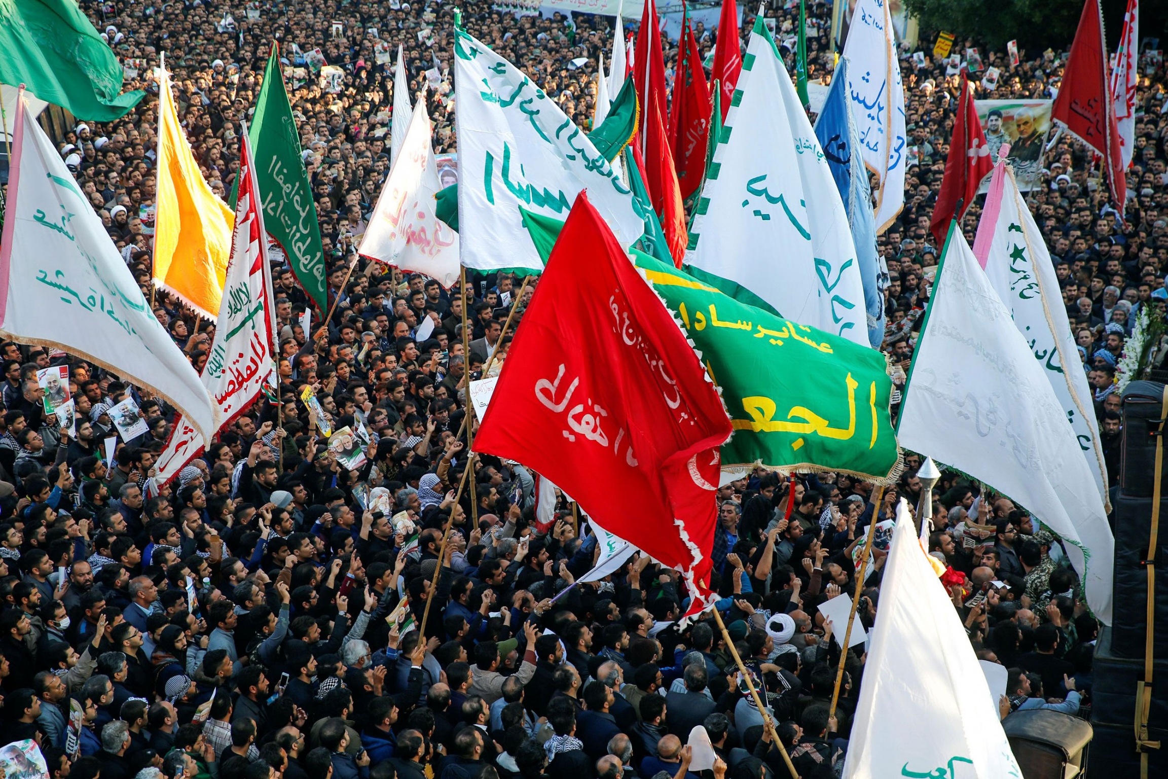 People attend a funeral procession for Iranian Maj. Gen. Qasem Soleimani and Iraqi militia commander Abu Mahdi al-Muhandis, who were killed in an airstrike at Baghdad airport, in Ahvaz, Iran, Jan. 5, 2020. A large crowd of people are shown from above with dozens of flags waving.