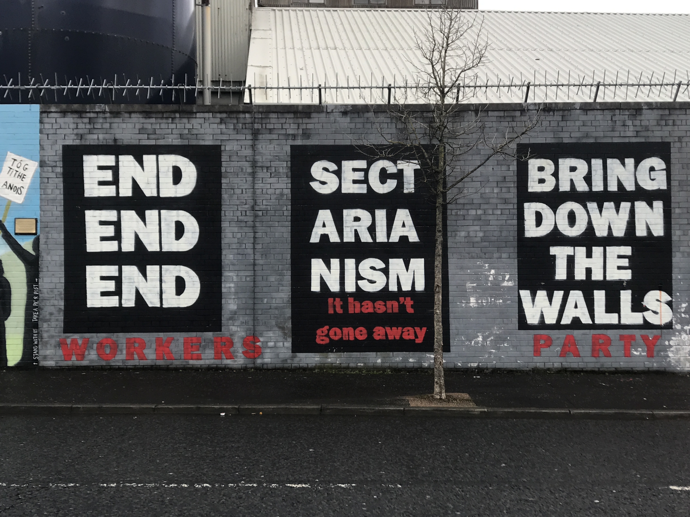 Um mural mostra mensagens relacionadas com o fim do sectarismo e a demolição de muros em Belfast, Irlanda do Norte.