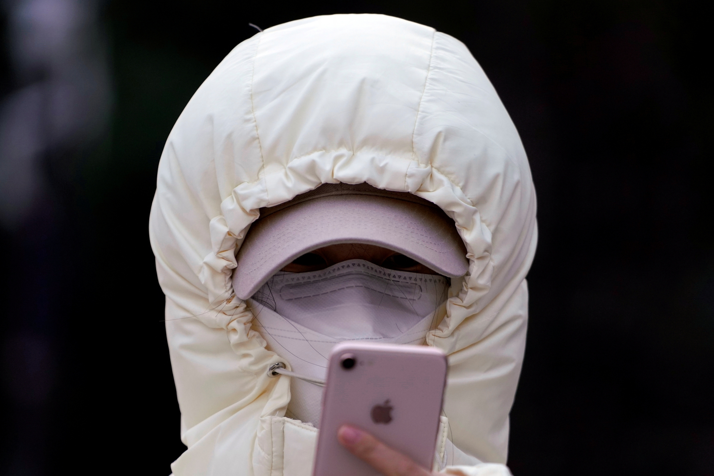 A woman wearing a mask checks her mobile phone in Shanghai, Jan. 29, 2020. A woman wearing a mask checks her mobile phone in Shanghai, Jan. 29, 2020.