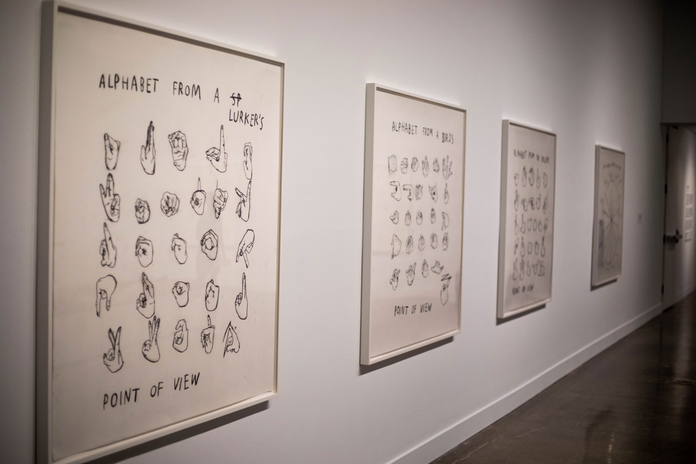 Several of Christine Sun Kim's pieces on display at MIT's List Visual Arts Center. Several charcoal diagrams are shown framed and hanging on a white wall.