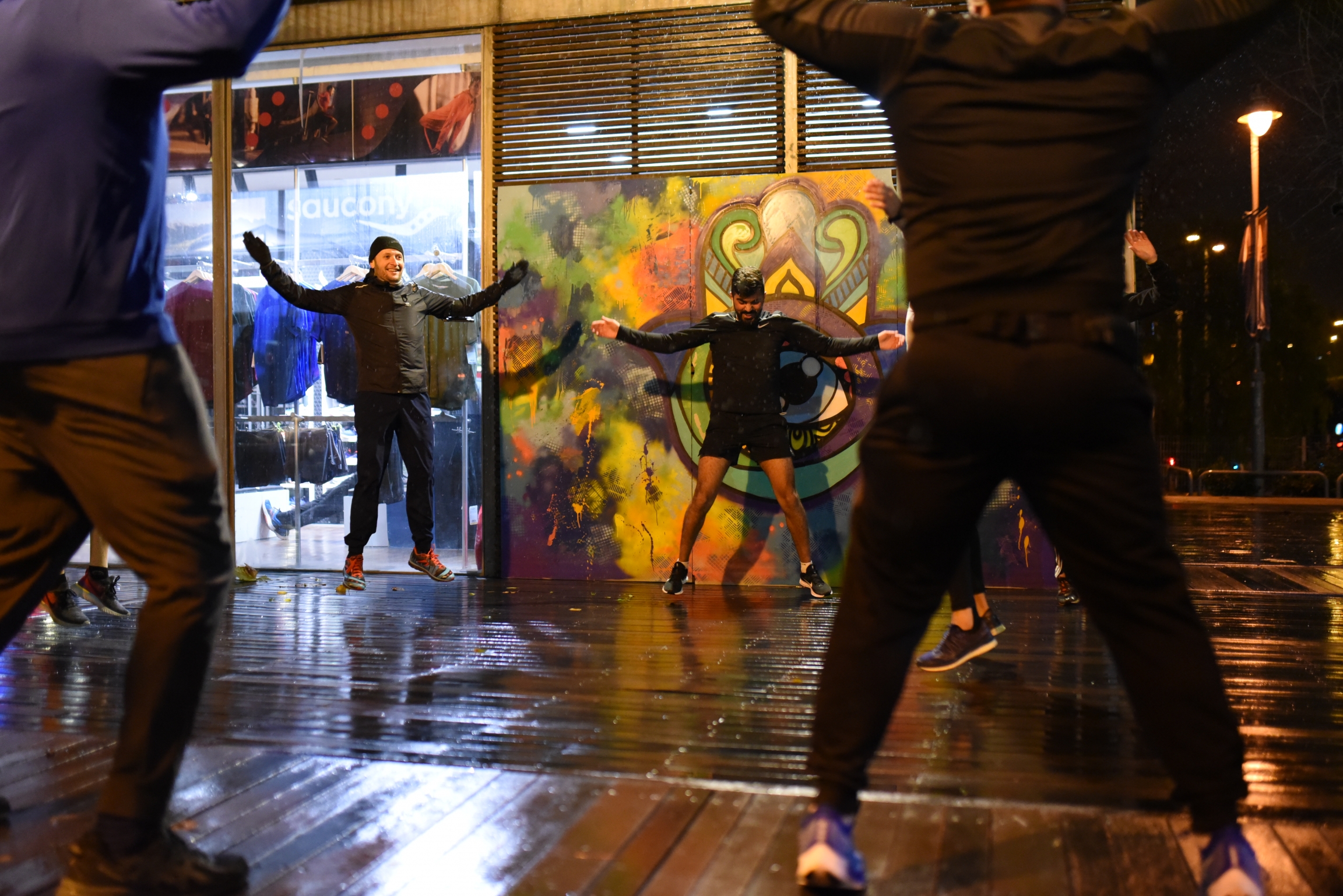 Right to Movement members warm up, led by Mahmoud Lafi. Runners jump up and down to warm up.
