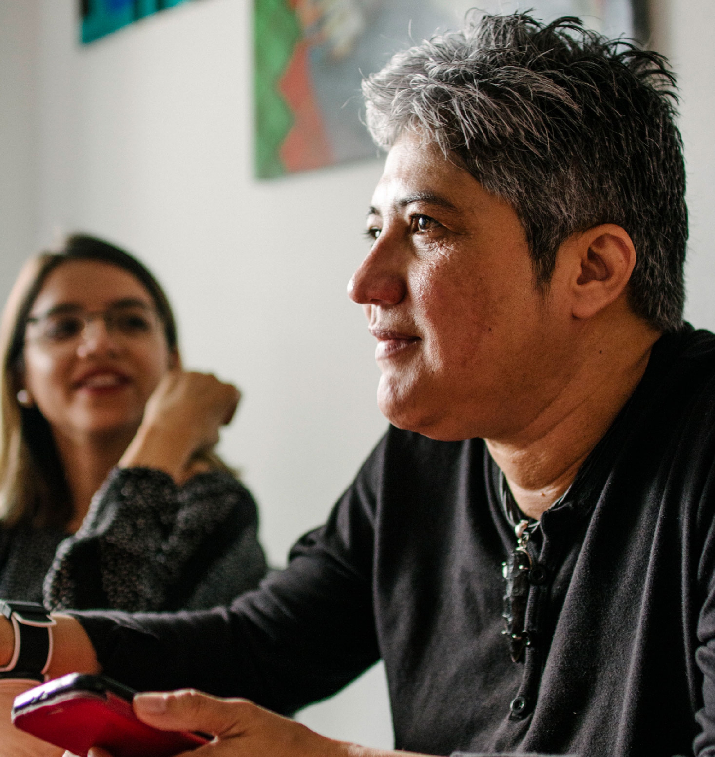 Indyra Mendoza, founder of Cattrachas, an organization that has been documenting instances of violence against the LGBTQ+ community for over 20 years. Indyra Mendoza is shown with a dark shirt on and holding a phone.