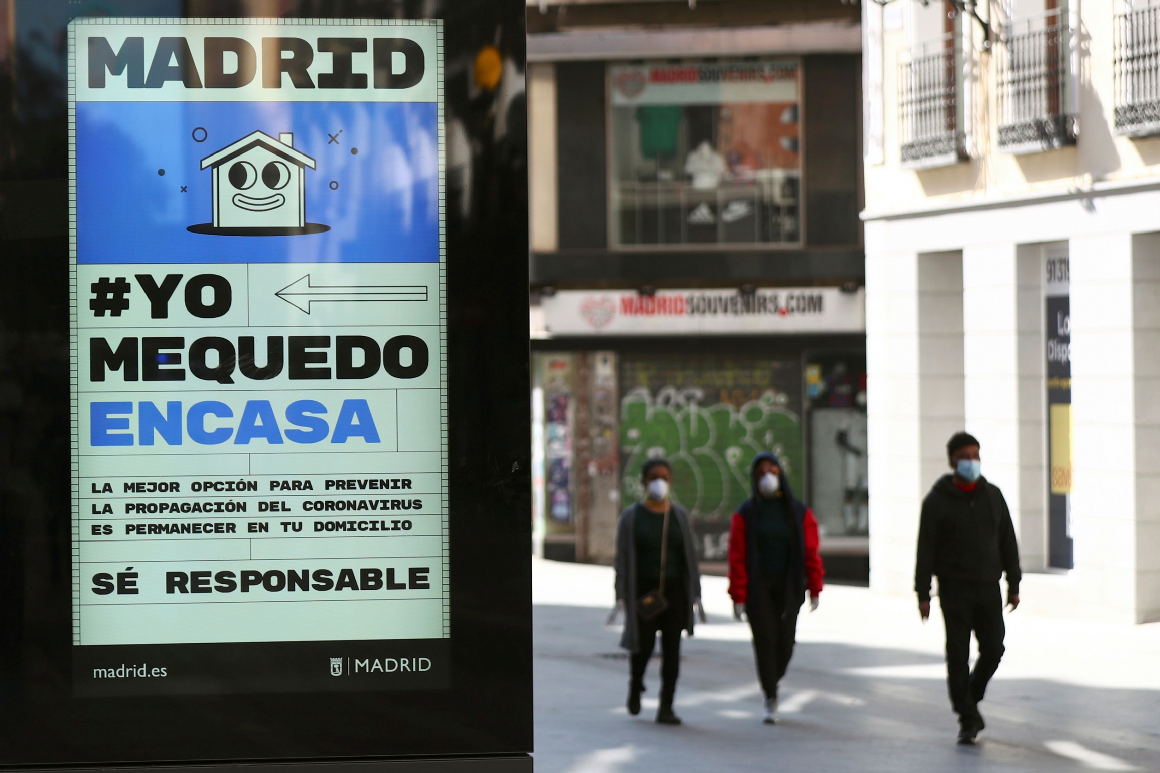 An ad advising people to be responsible and stay home is displayed at the almost empty Preciados street due to the coronavirus outbreak in central Madrid, Spain, March 14, 2020. An ad on a street tells people to stay at home.