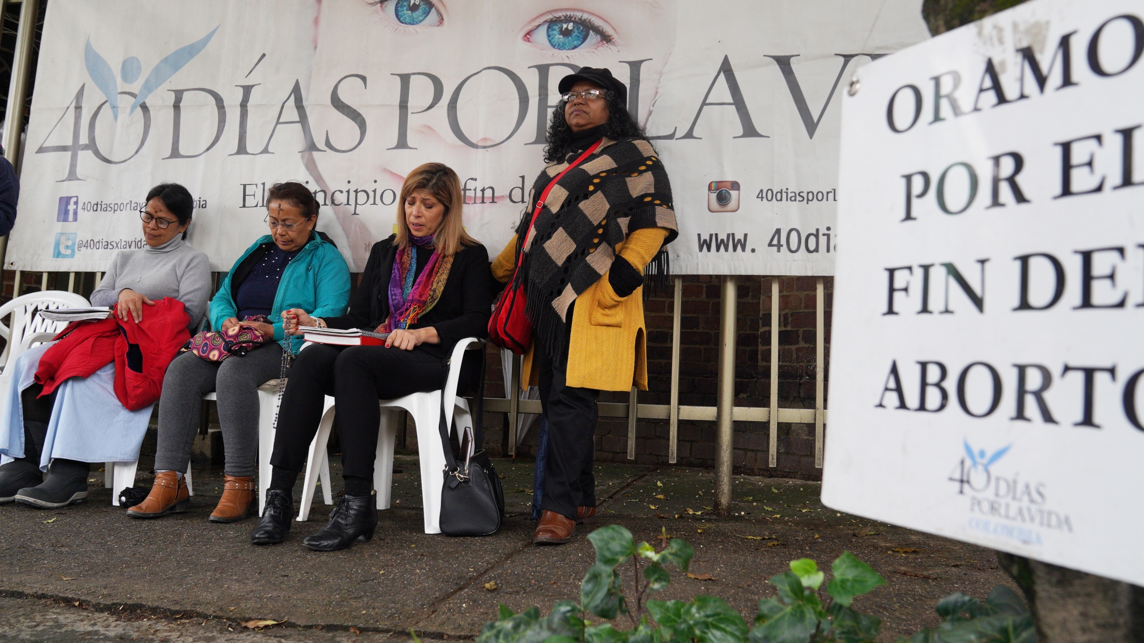 Yerlin Pineda (center) prays outside an abortion clinic in Bogotá, Colombia, during a vigil organized by the Texas-based anti-abortion group, 40 Days for Life. Four women pray outside at an anti-abortion vigil.