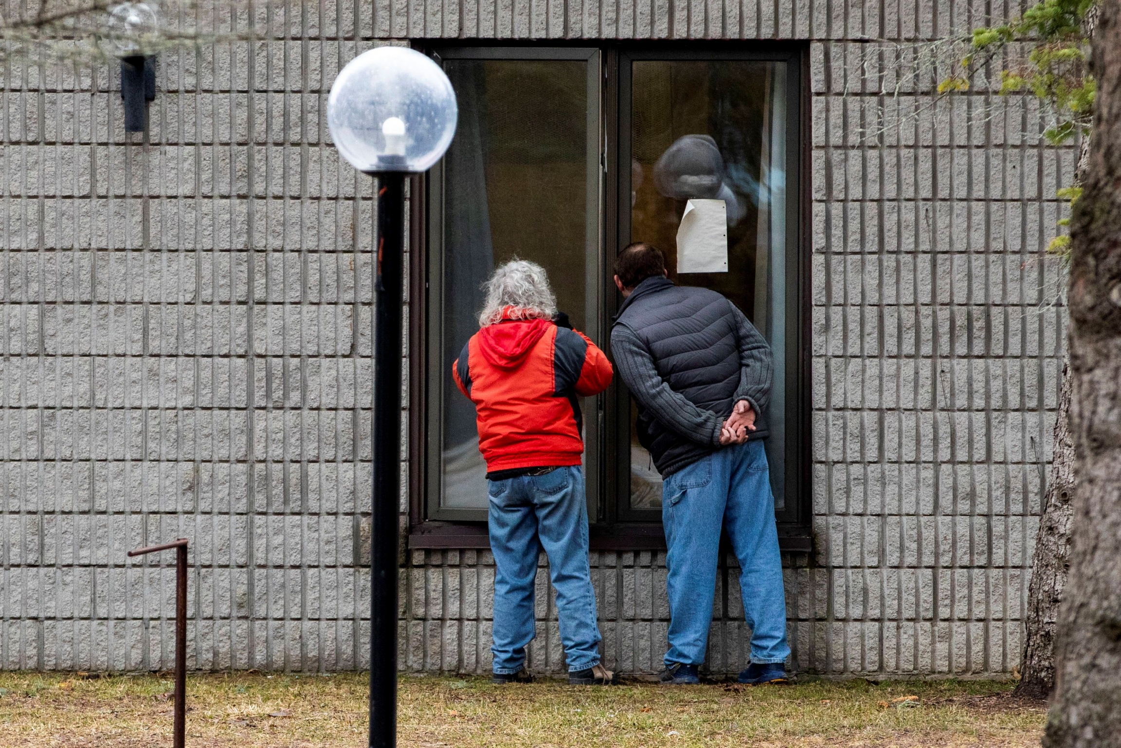 Two people speak to a resident through a window at Pinecrest Nursing Home after several residents died and dozens of staff were sickened by coronavirus disease (COVID-19) in Bobcaygeon, Ontario, Canada, on March 30, 2020. Two people speak to a resident through a window at Pinecrest Nursing Home after several residents died and dozens of staff were sickened by coronavirus disease (COVID-19) in Bobcaygeon, Ontario, Canada, on March 30, 2020.