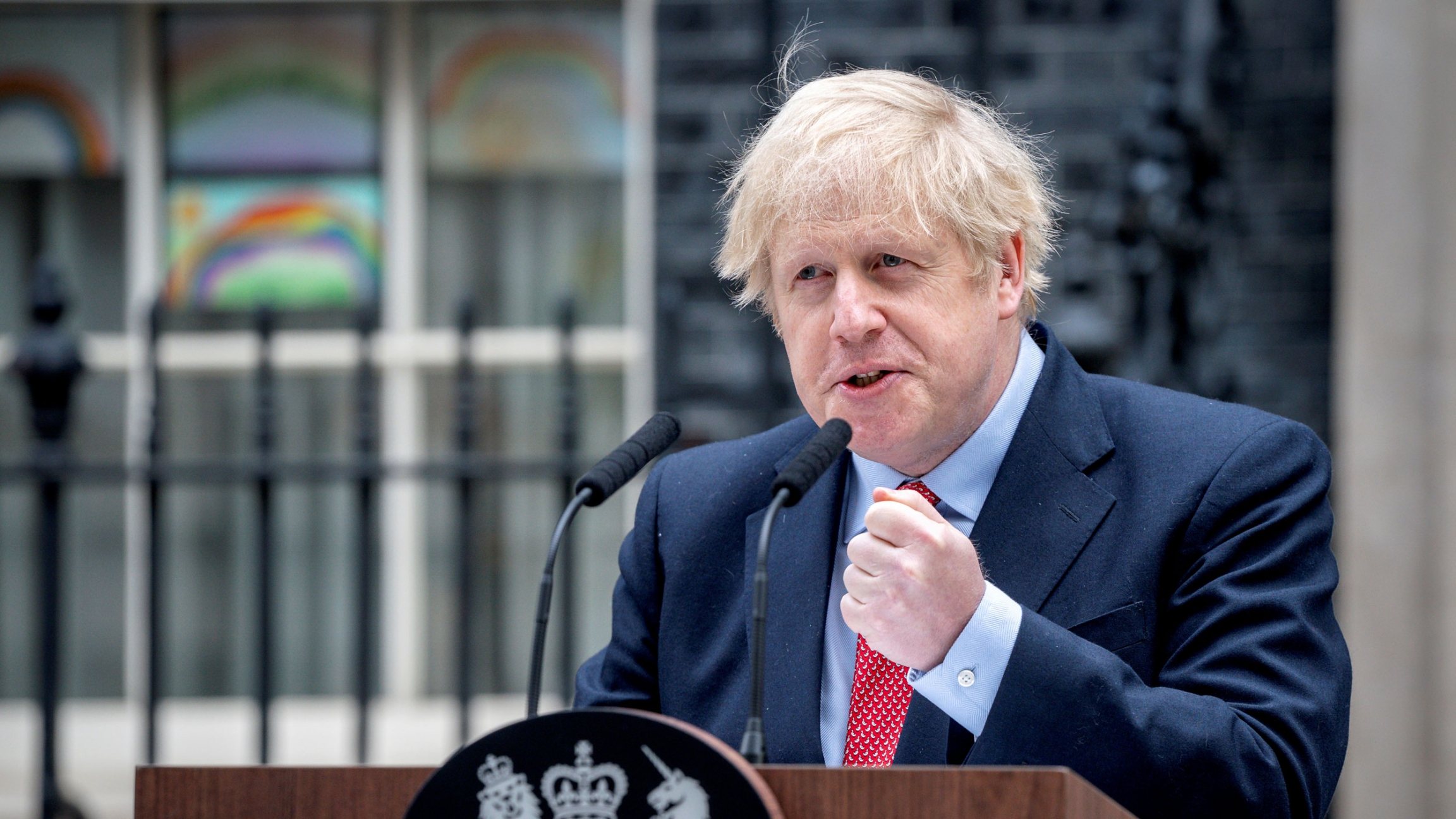 Britain's Prime Minister Boris Johnson speaks outside 10 Downing Street after recovering from the coronavirus, in London, England, April 27, 2020. Britain's Prime Minister Boris Johnson is shown speaking from a wooden podium with his fist raised and clenched.