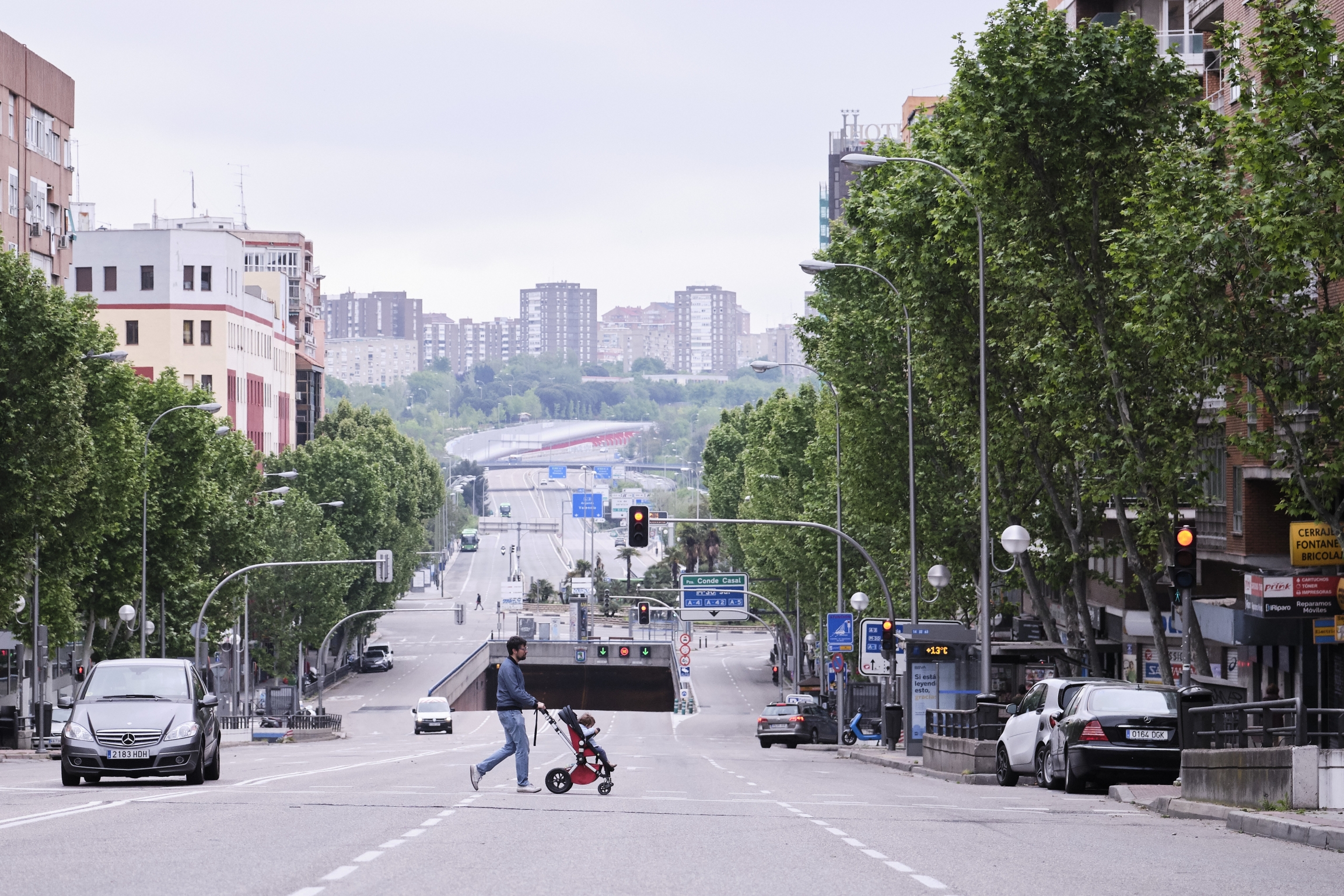 A man walks a baby across the street in a pushchair in Madrid as Spain lifts restrictions on children outdoors due to the coronavirus pandemic. A man walks a baby across the street in a pushchair in Madrid as Spain lifts restrictions on children outdoors due to the coronavirus pandemic.