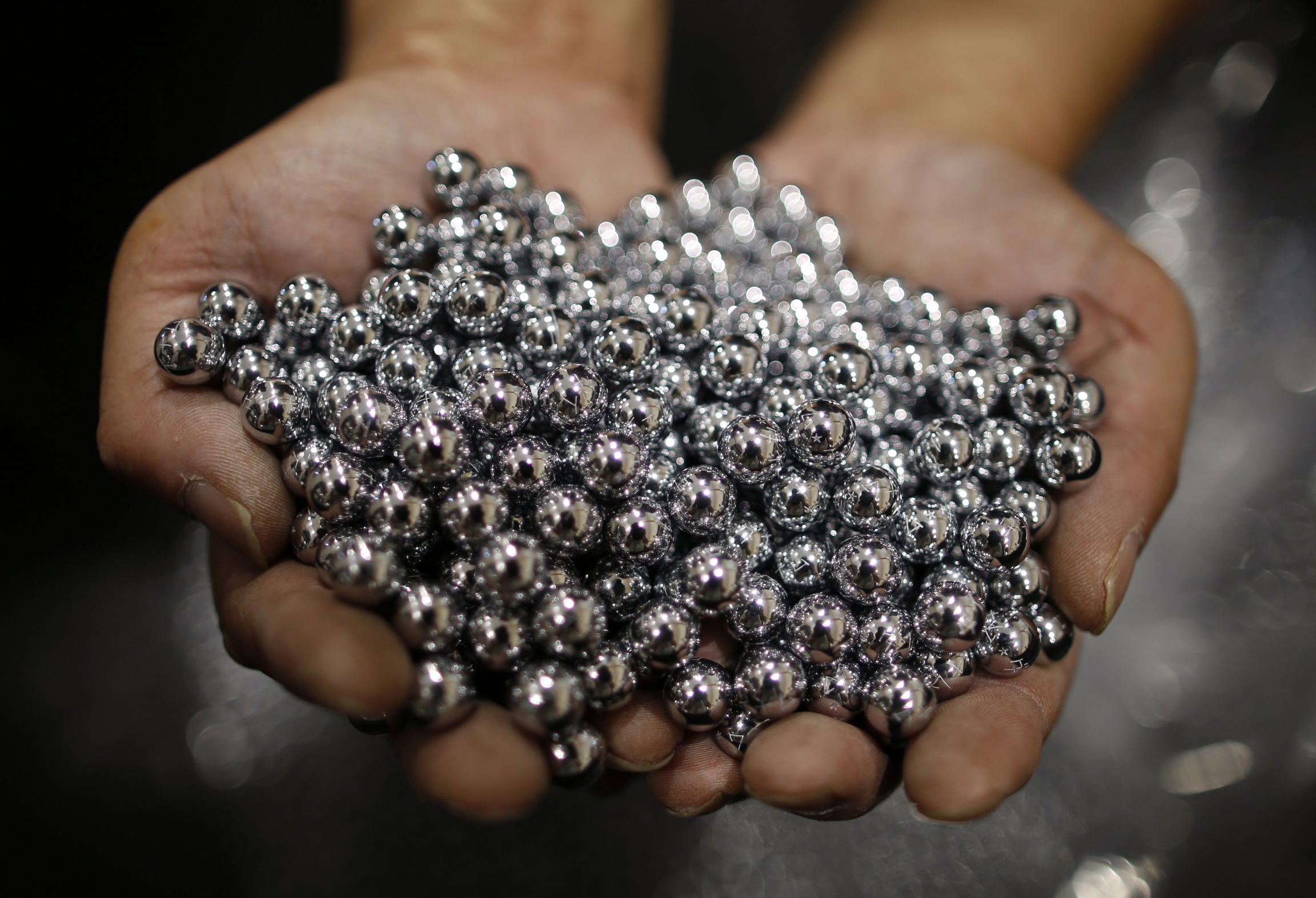 A worker holds silver pachinko balls at a pachinko parlour in Fukaya, north of Tokyo, July 15, 2014. A worker holds silver pachinko balls at a pachinko parlour in Fukaya, north of Tokyo, July 15, 2014.