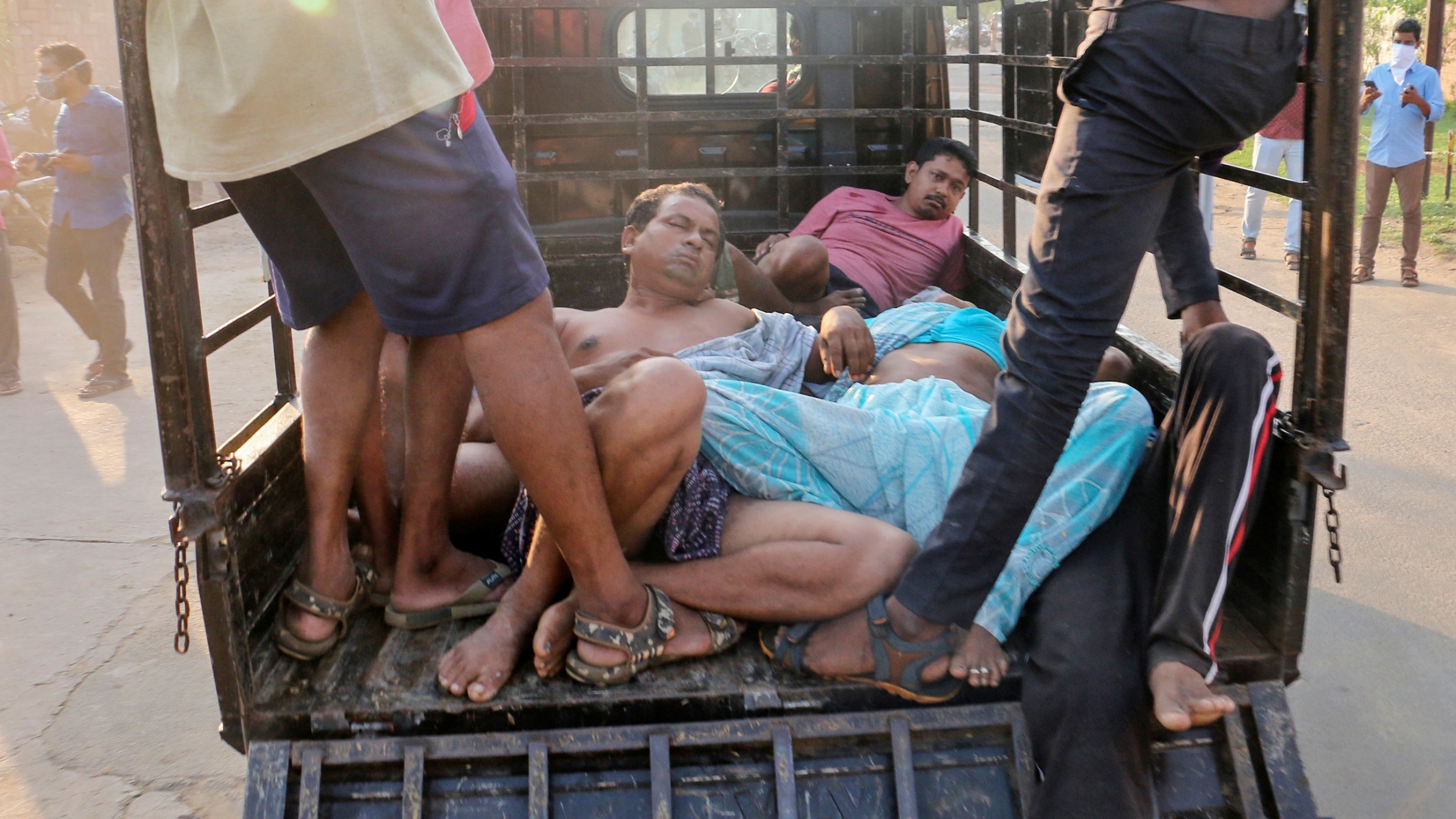 People affected by gas leak at the LG Polymers Plant are transported in a vehicle in Visakhapatnam, India, May 7, 2020. Several people are shown laying in the bed of a pickup truck.