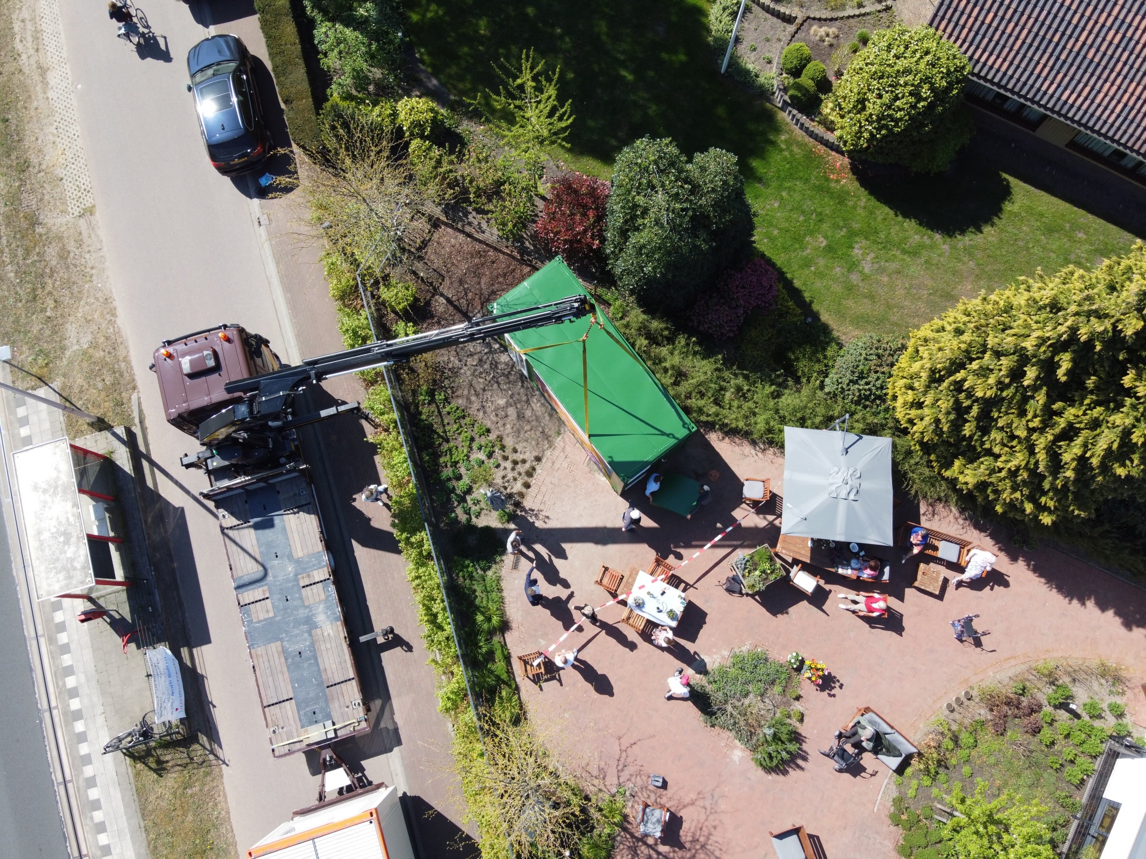 The Glass Garden House was designed to allow family and friends to visit elders at the nursing home during the coronavirus pandemic. Installing the glass cabin with a large crane, aerial shot.