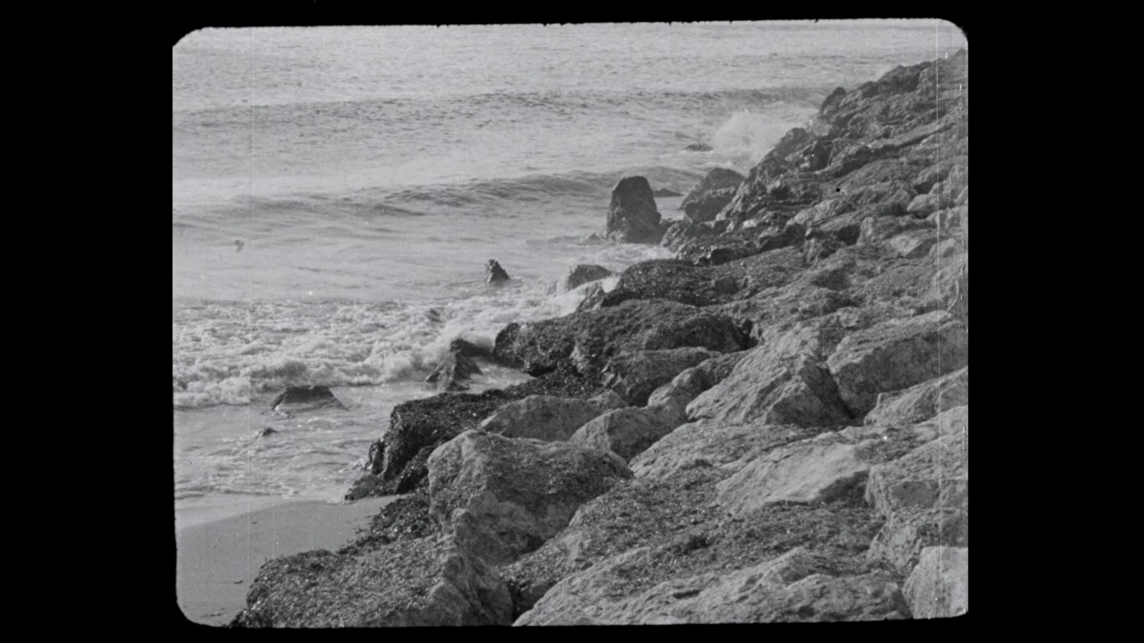 A seaside image from the film "Mallorca" by María Forteza. Her only film, she made it to draw tourists to the island a couple of decades before it became a popular holiday destination. A seaside image from a black and white film.